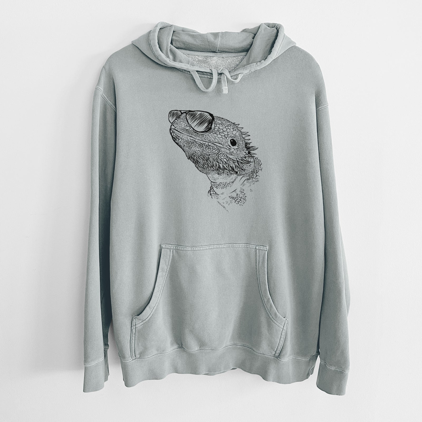 Hand-drawn sketch of Ash the Bearded Dragon wearing aviator sunglasses on a Sage Unisex pigment dyed hoodie