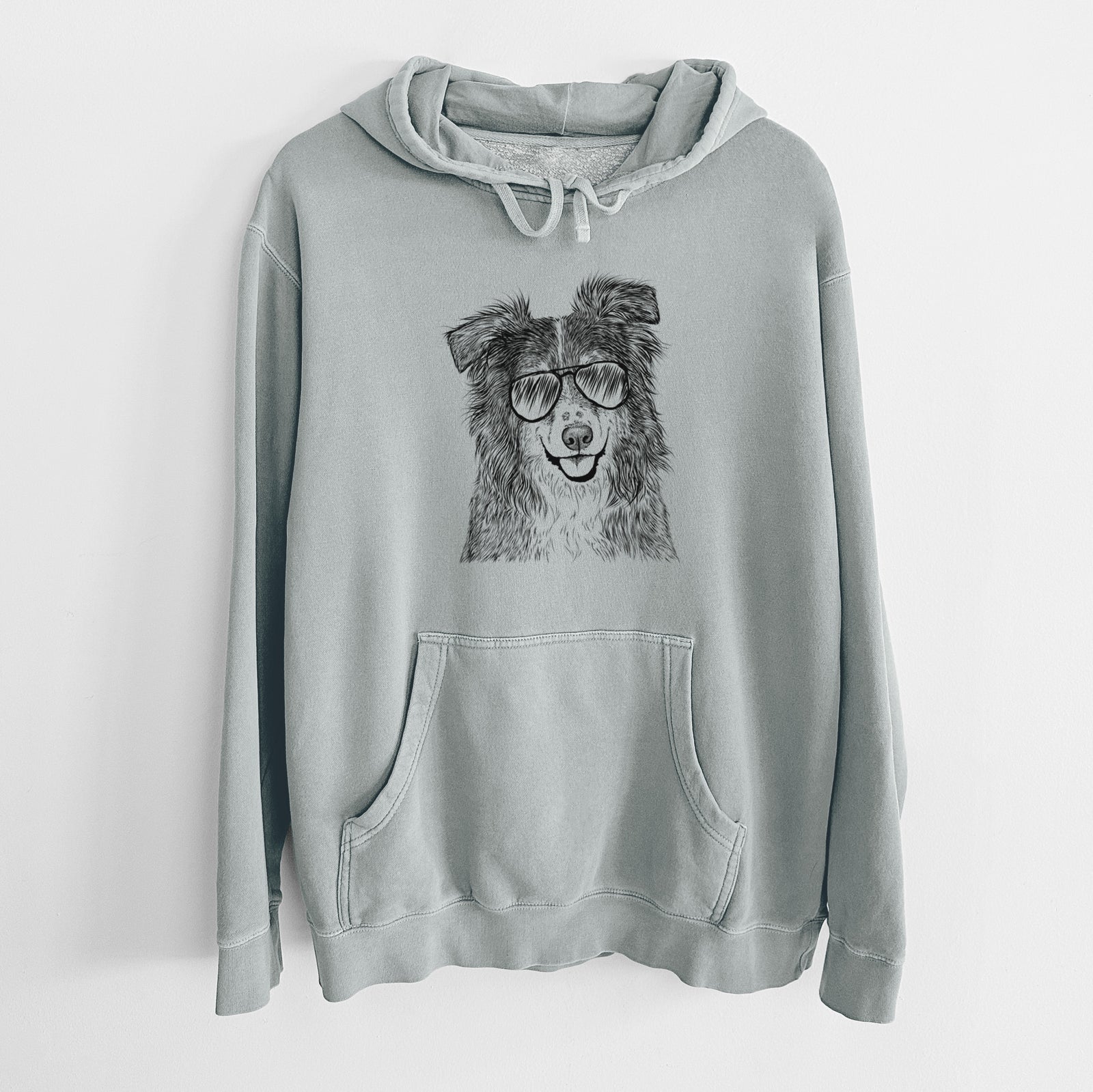 Hand-drawn sketch of Aushe the Australian Shepherd wearing aviator sunglasses on a Sage Unisex pigment dyed hoodie