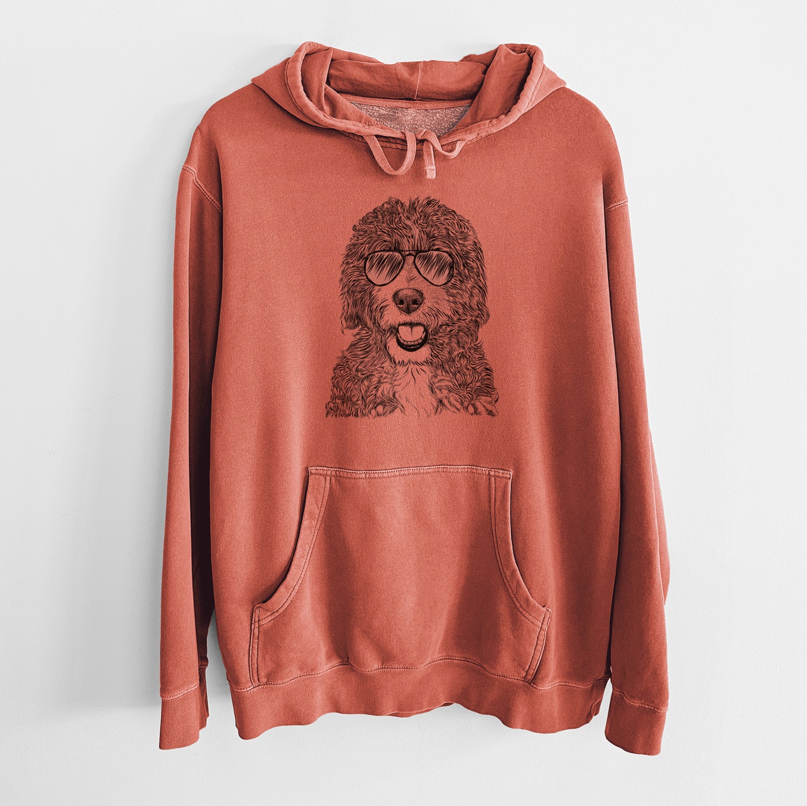 Hand-drawn sketch of Bash the Bernedoodle wearing aviator sunglasses on an Amber Unisex pigment dyed hoodie