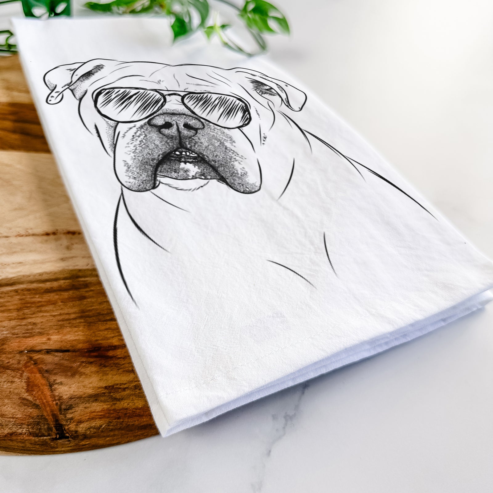 Hand-drawn sketch of Blossom the English Bulldog wearing aviator sunglasses on a tea towel