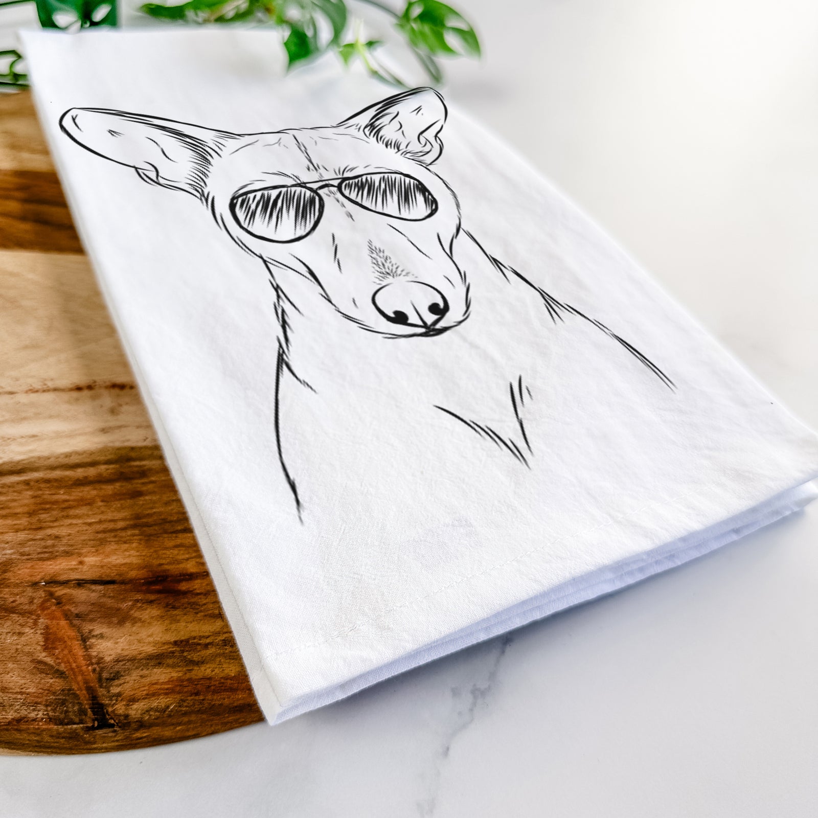 Hand-drawn sketch of Buff the Dorgi wearing aviator sunglasses on a tea towel