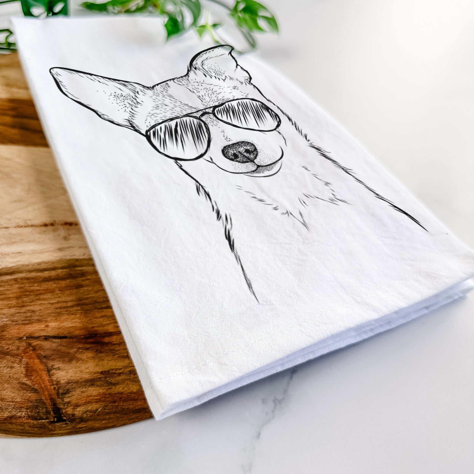 Hand-drawn sketch of Buggy the Chihuahua wearing aviator sunglasses on a tea towel