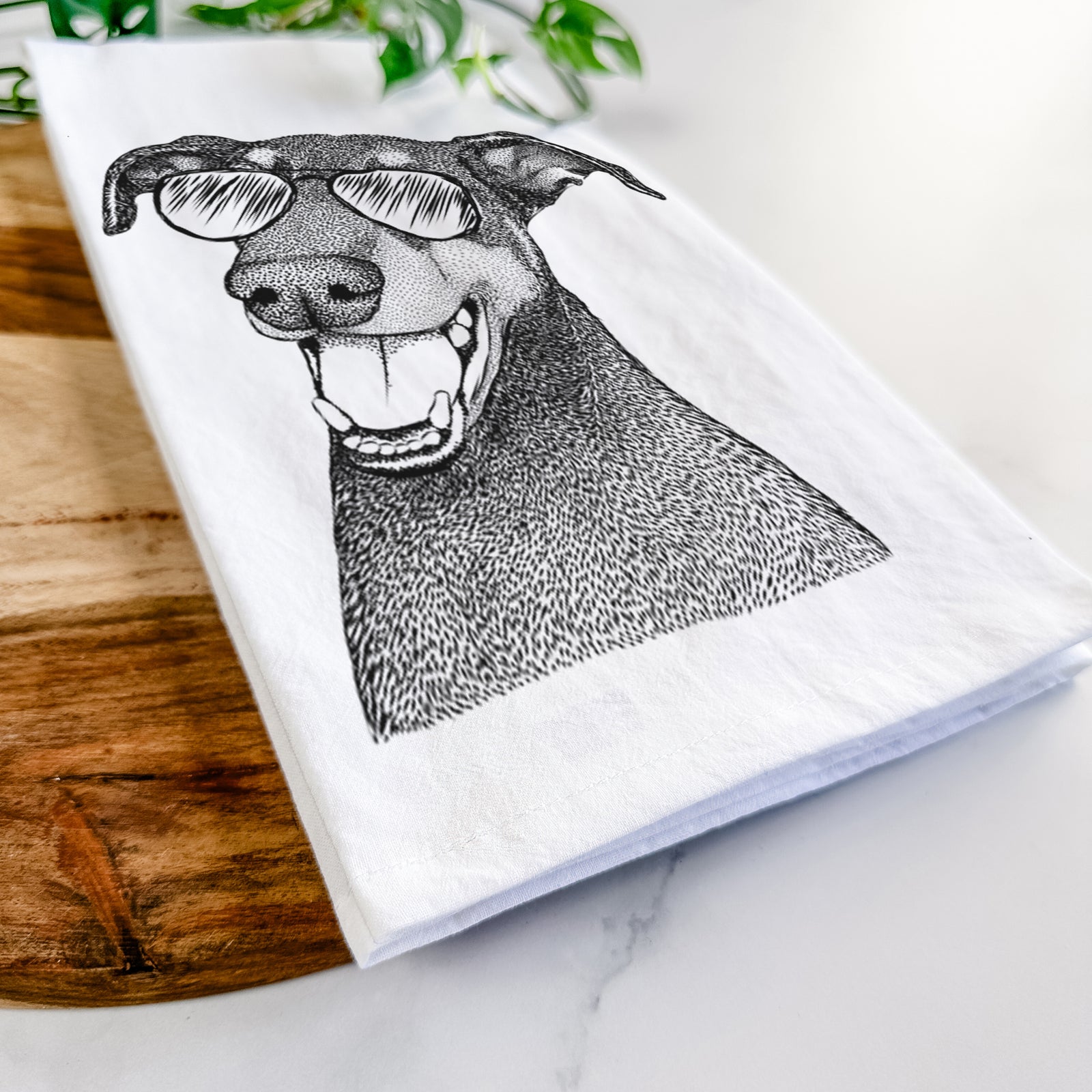 Hand-drawn sketch of Bunnie the Doberman Pinscher wearing aviator sunglasses on a tea towel