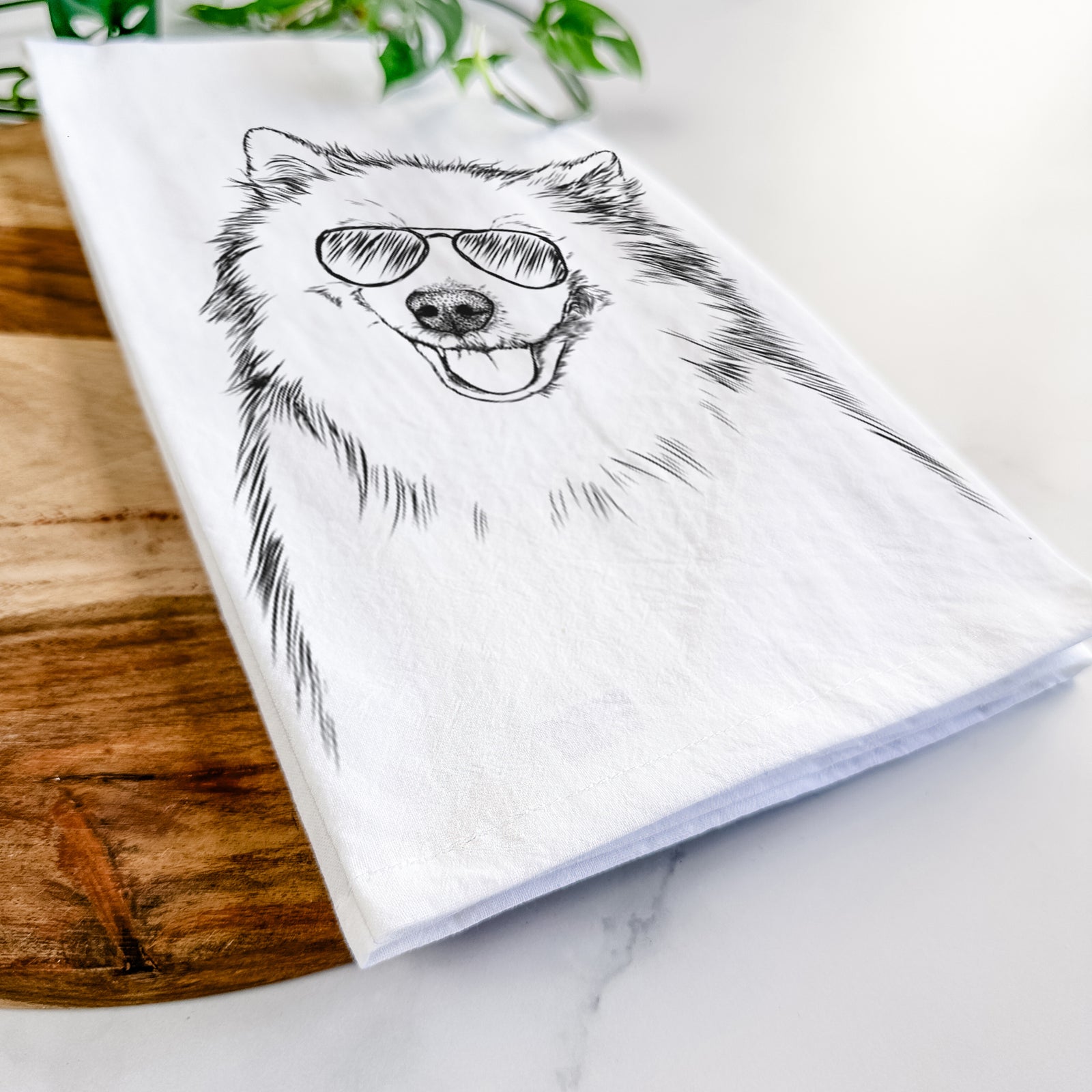 Hand-drawn sketch of Caico the Samoyed wearing aviator sunglasses on a tea towel