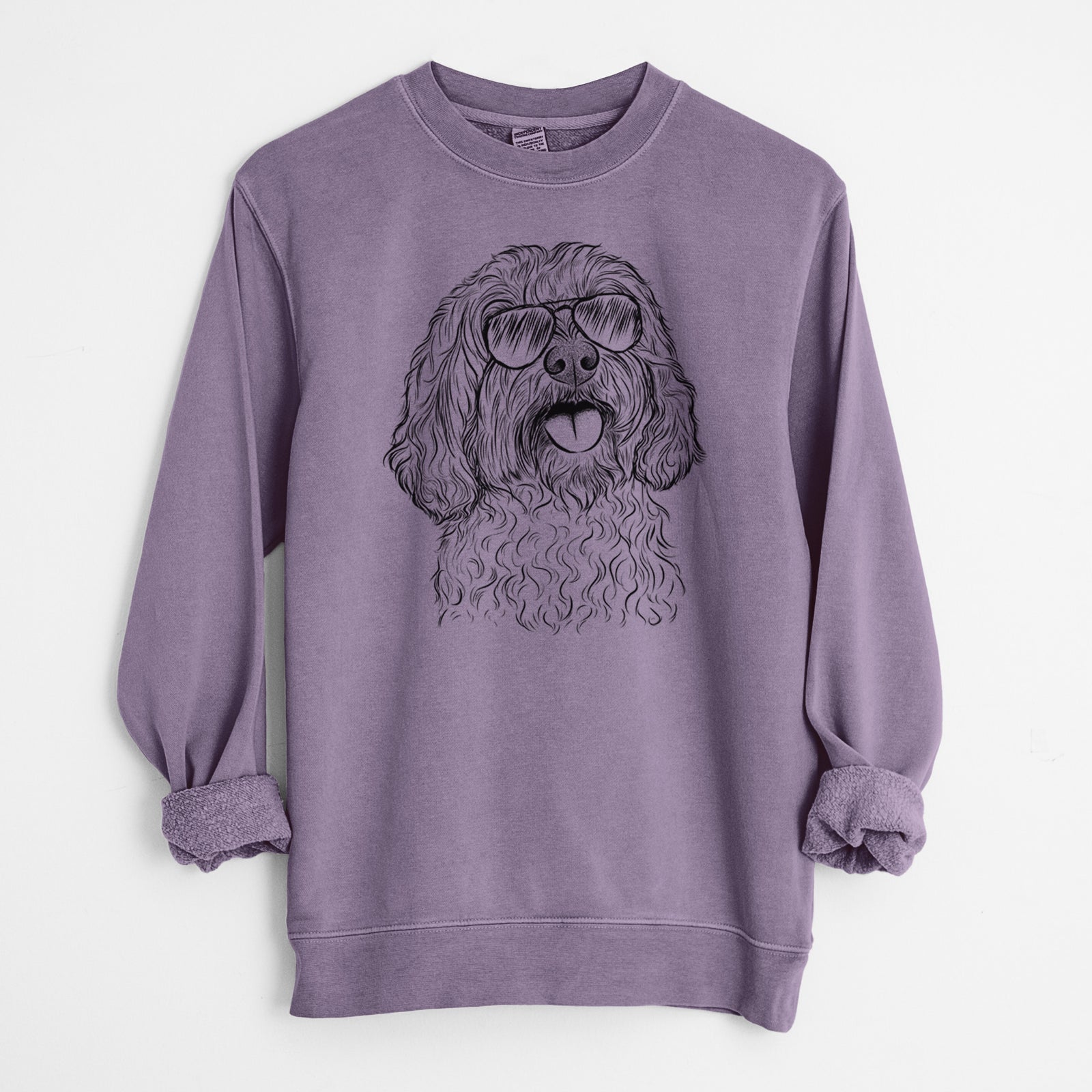 Hand-drawn sketch of Cali the Cavapoo wearing aviator sunglasses on a Plum Unisex pigment dyed crew sweatshirt
