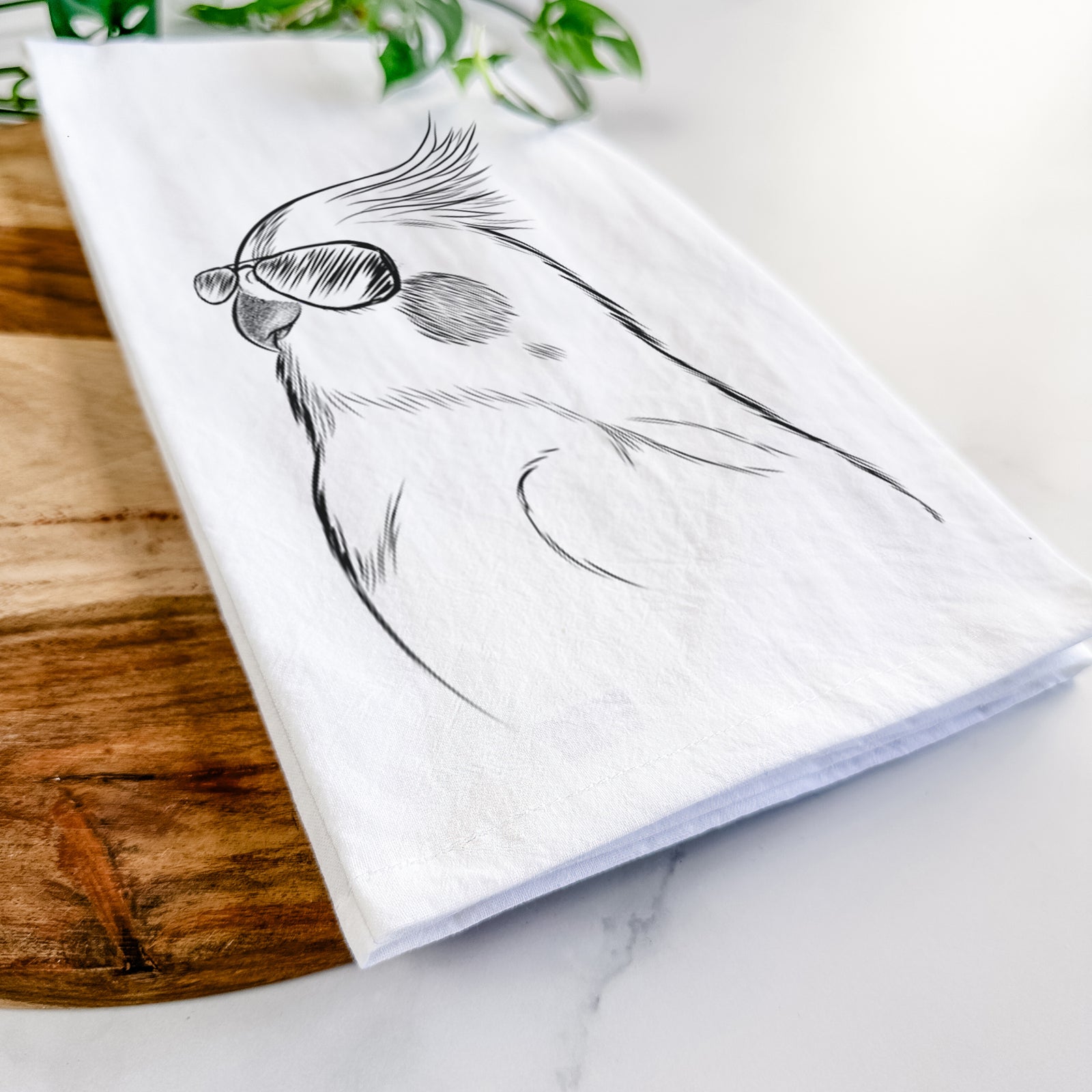 Hand-drawn sketch of Charlie the Cockatiel wearing aviator sunglasses on a tea towel