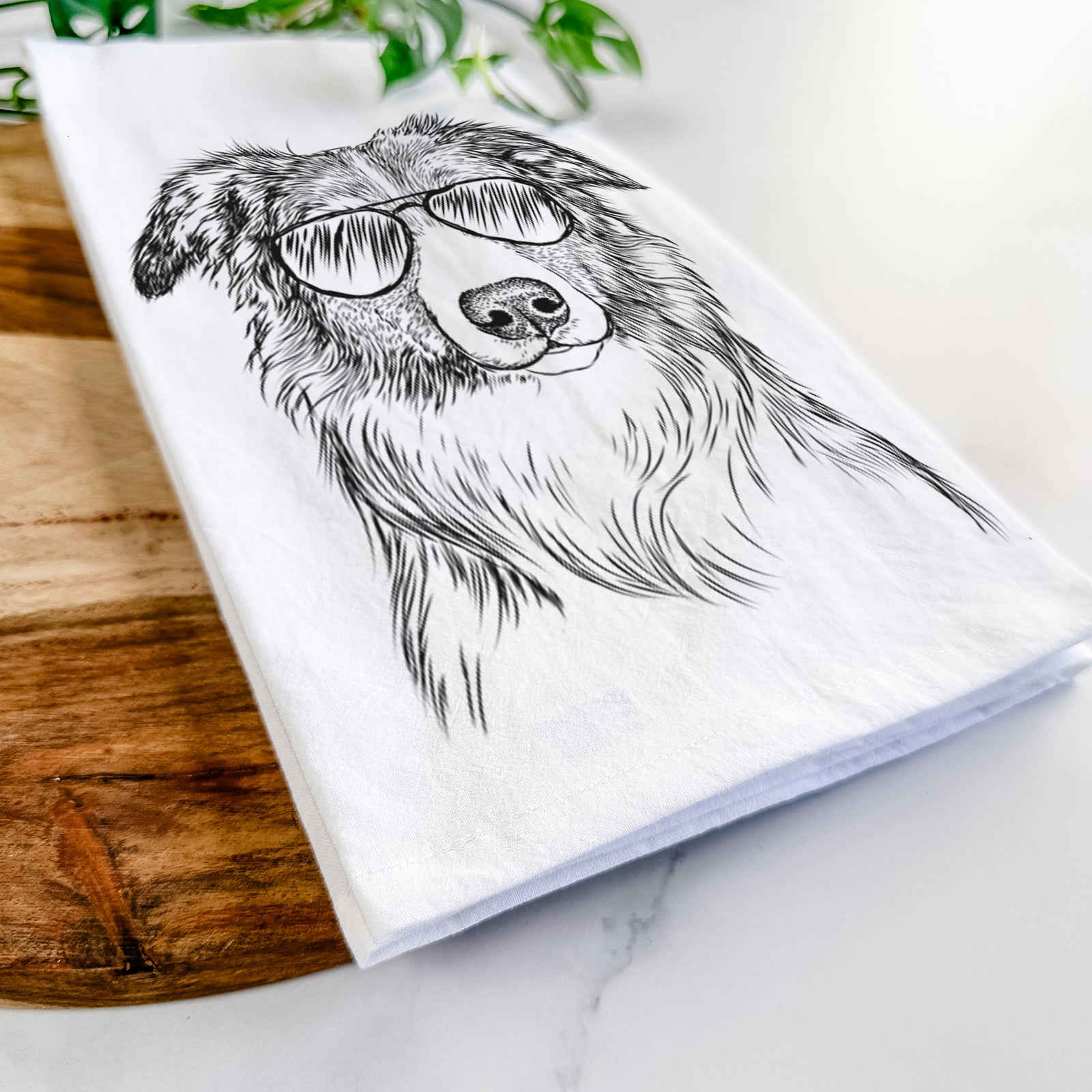 Hand-drawn sketch of Cynder the English Shepherd wearing aviator sunglasses on a tea towel