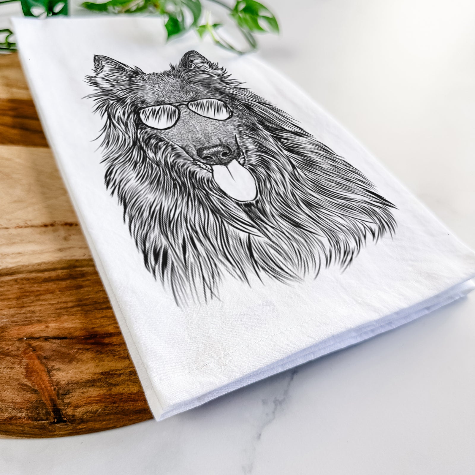 Hand-drawn sketch of Daan the Belgian Shepherd wearing aviator sunglasses on a tea towel