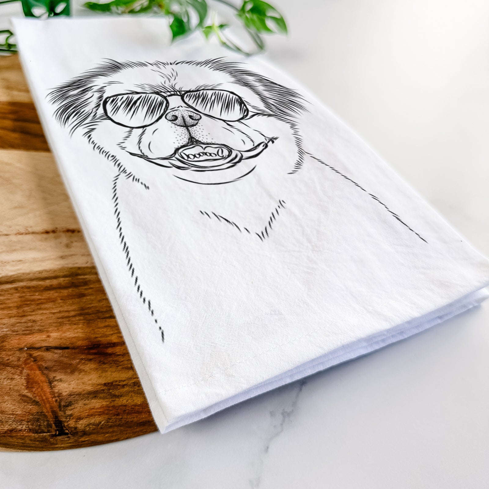 Hand-drawn sketch of Danny the Pekingese wearing aviator sunglasses on a tea towel