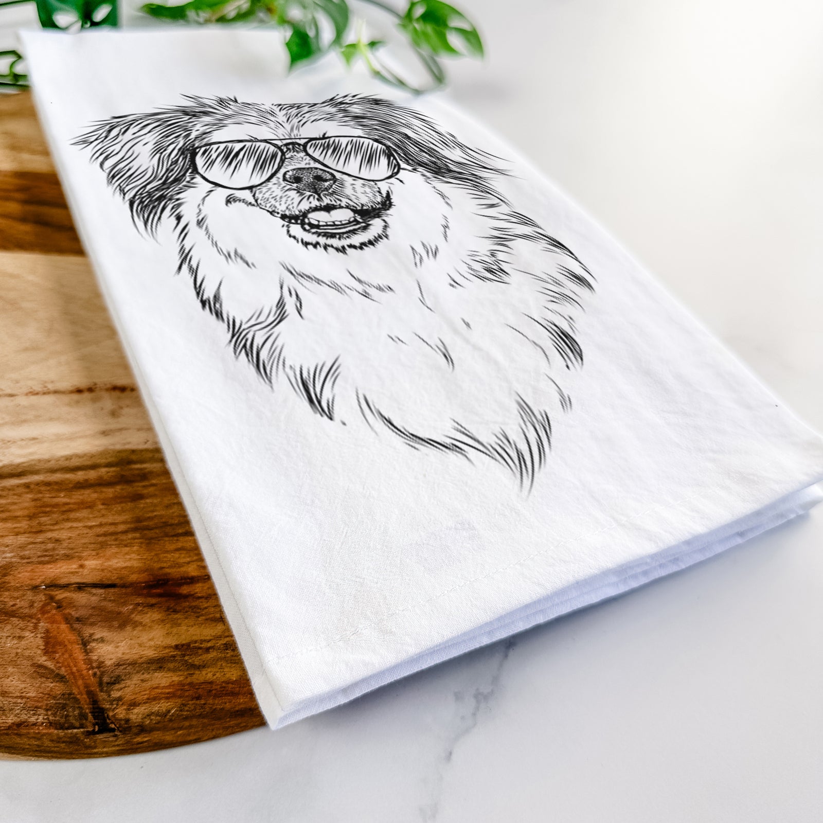 Hand-drawn sketch of Ed the Tibetan Spaniel wearing aviator sunglasses on a tea towel