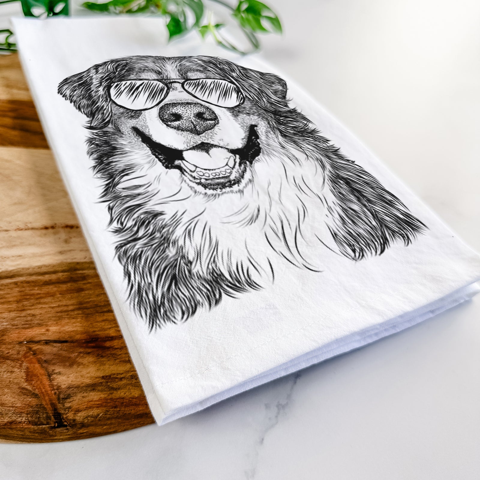 Hand-drawn sketch of Eiger the Bernese Mountain Dog wearing aviator sunglasses on a tea towel