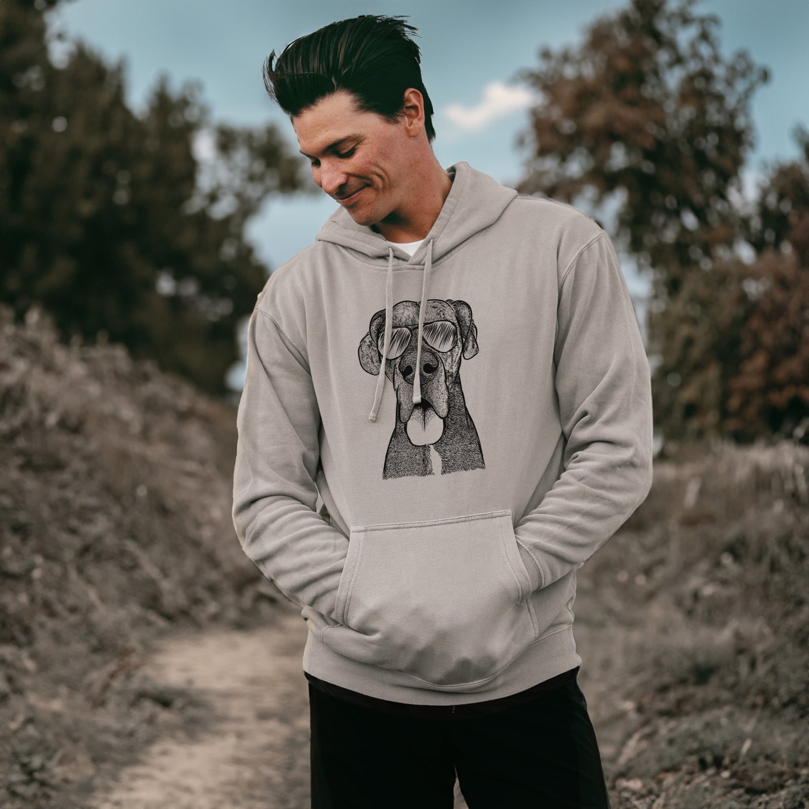 Hand-drawn sketch of Eli the Great Dane wearing aviator sunglasses on a Cement Unisex pigment dyed hoodie, worn by a man