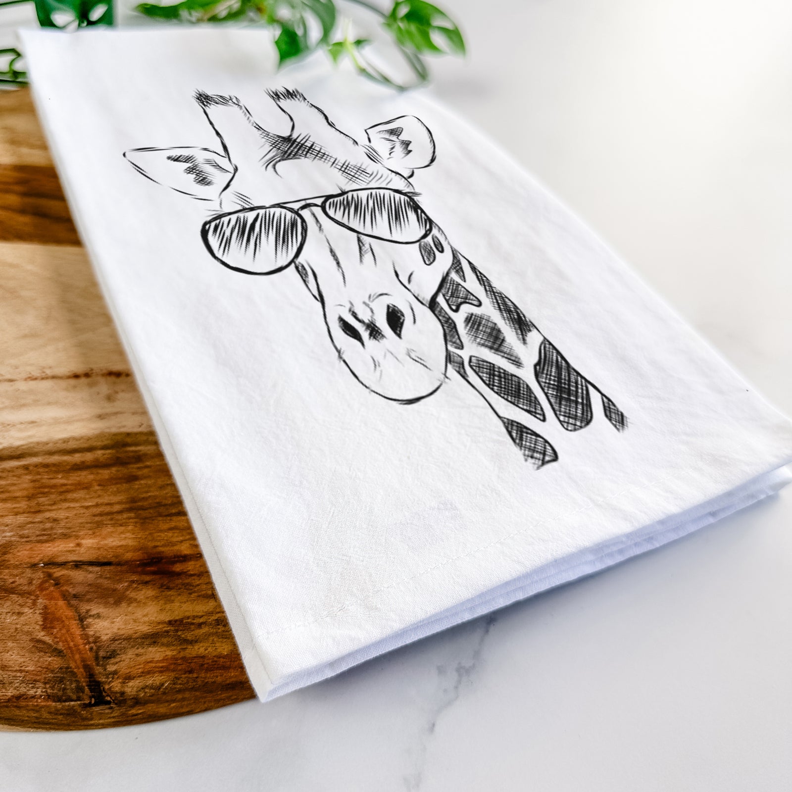 Hand-drawn sketch of Geoffrey the Giraffe wearing aviator sunglasses on a tea towel