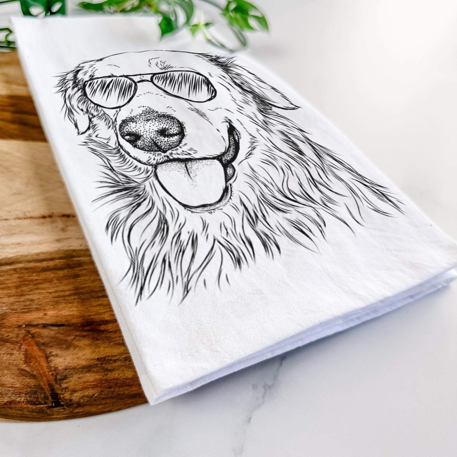 Hand-drawn sketch of Hopper the Golden Retriever wearing aviator sunglasses on a tea towel