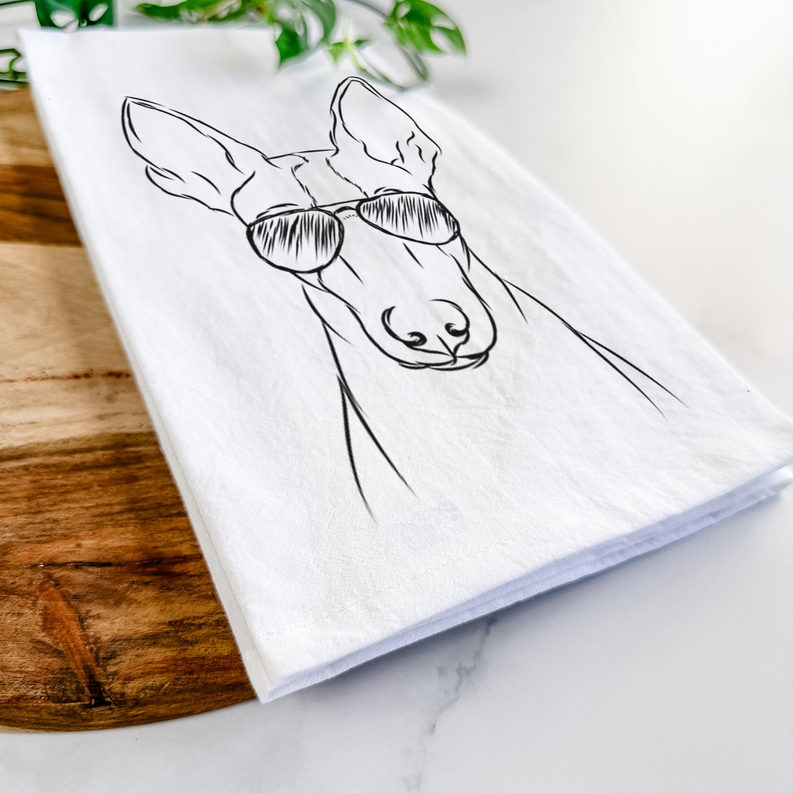 Hand-drawn sketch of Indy the Ibizan Hound wearing aviator sunglasses on a tea towel