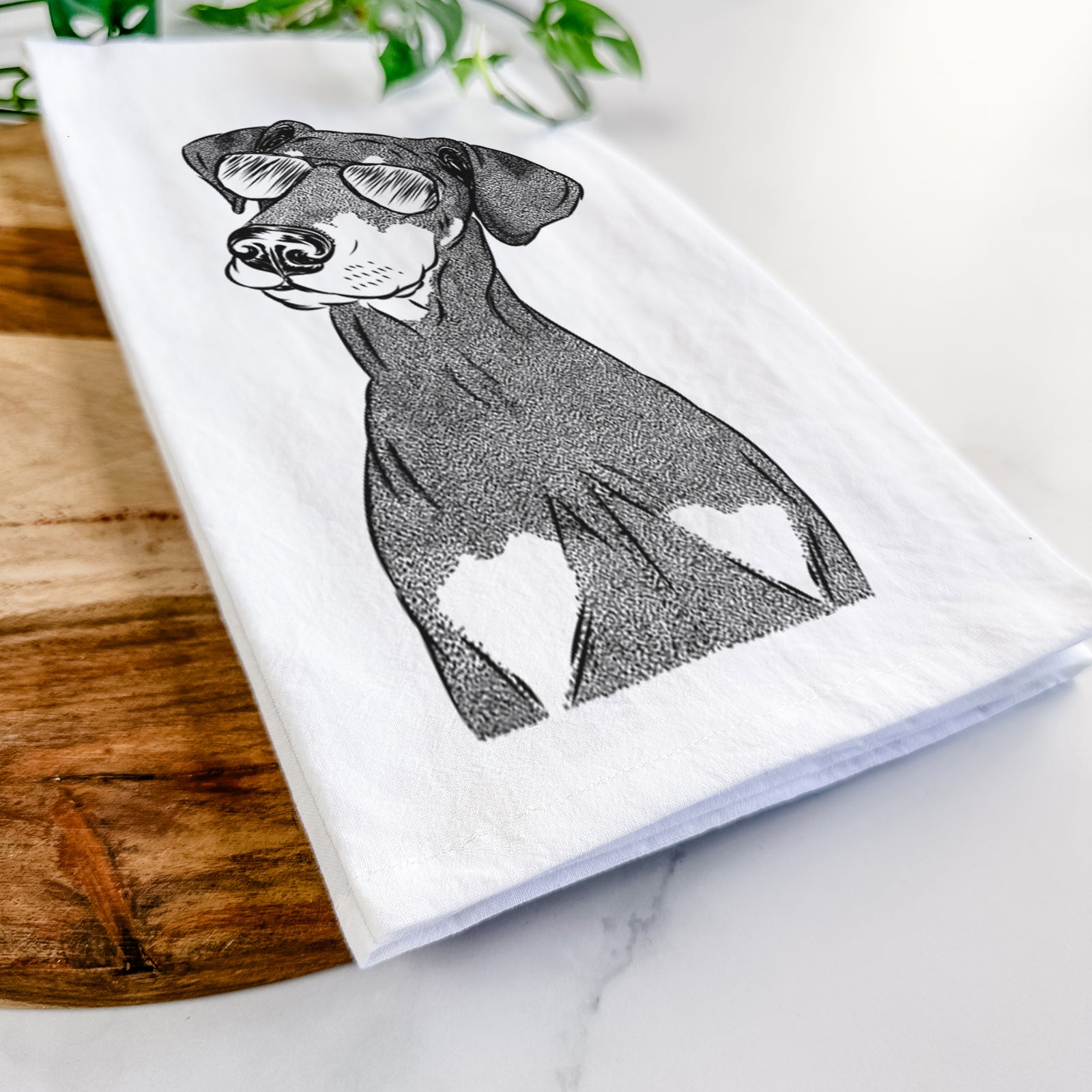 Hand-drawn sketch of Iroh the Doberman Pinscher wearing aviator sunglasses on a tea towel