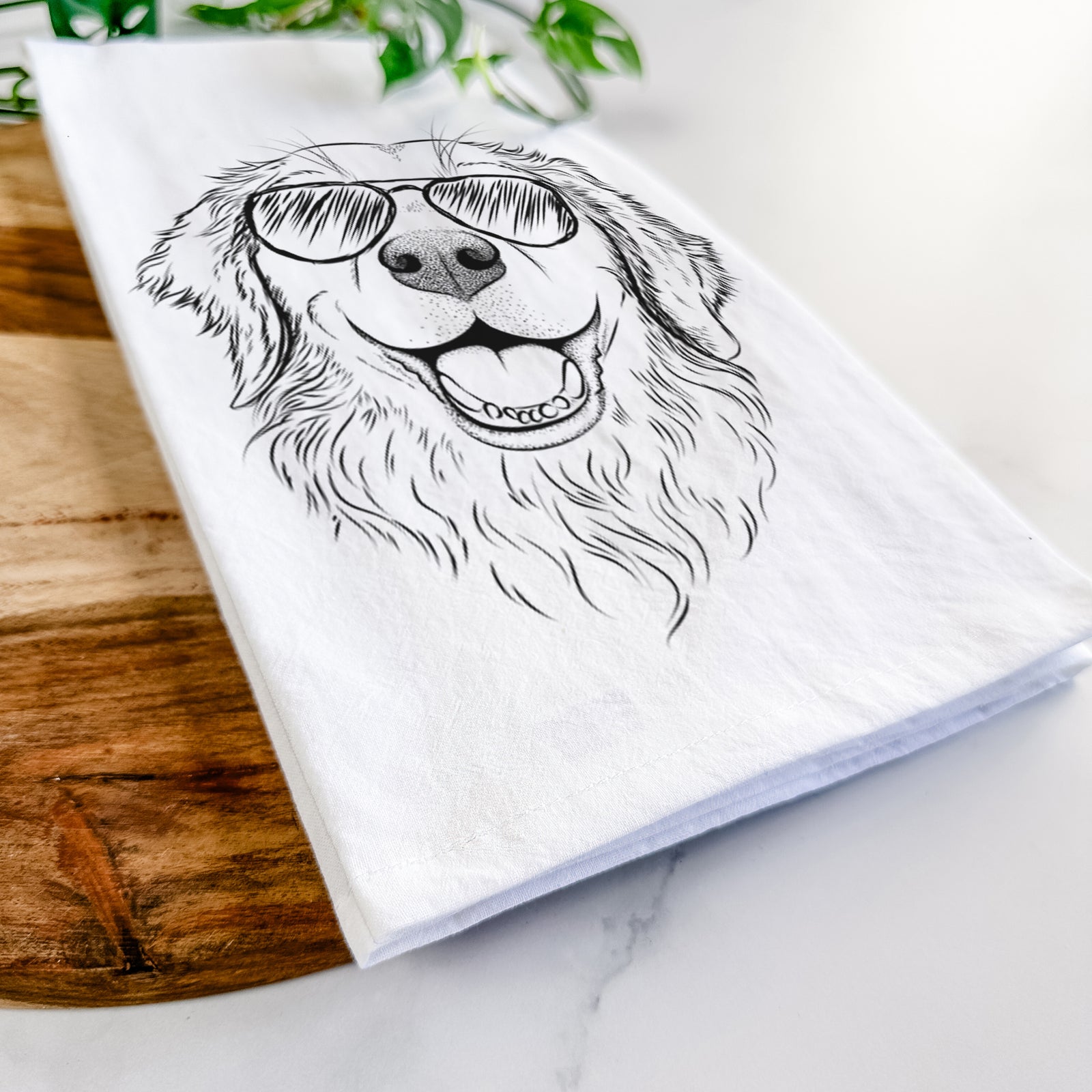 Hand-drawn sketch of Legend the Golden Retriever wearing aviator sunglasses on a tea towel