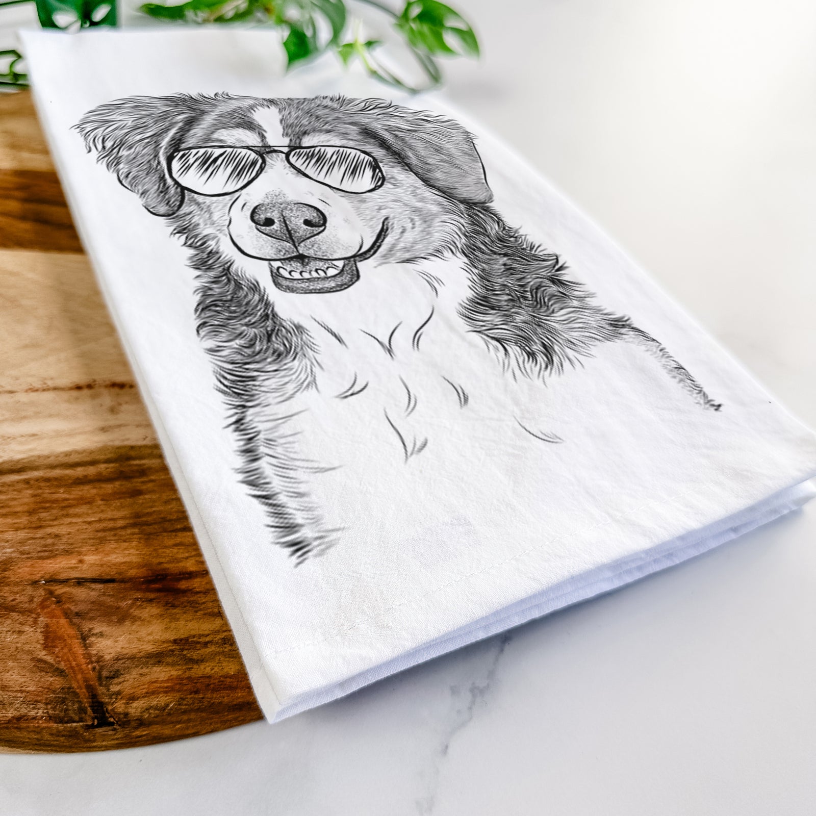 Hand-drawn sketch of Molly the Miniature Bernedoodle wearing aviator sunglasses on a tea towel