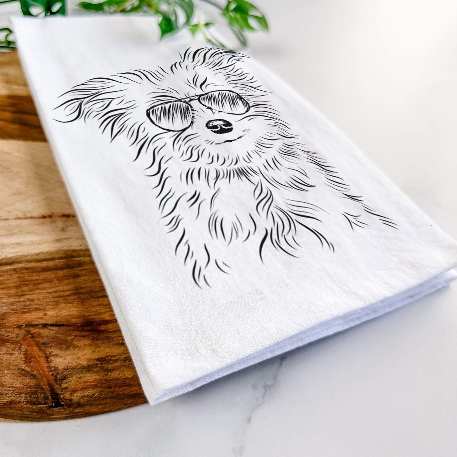 Hand-drawn sketch of Mr. Gucci Poochi the Maltese wearing aviator sunglasses on a tea towel