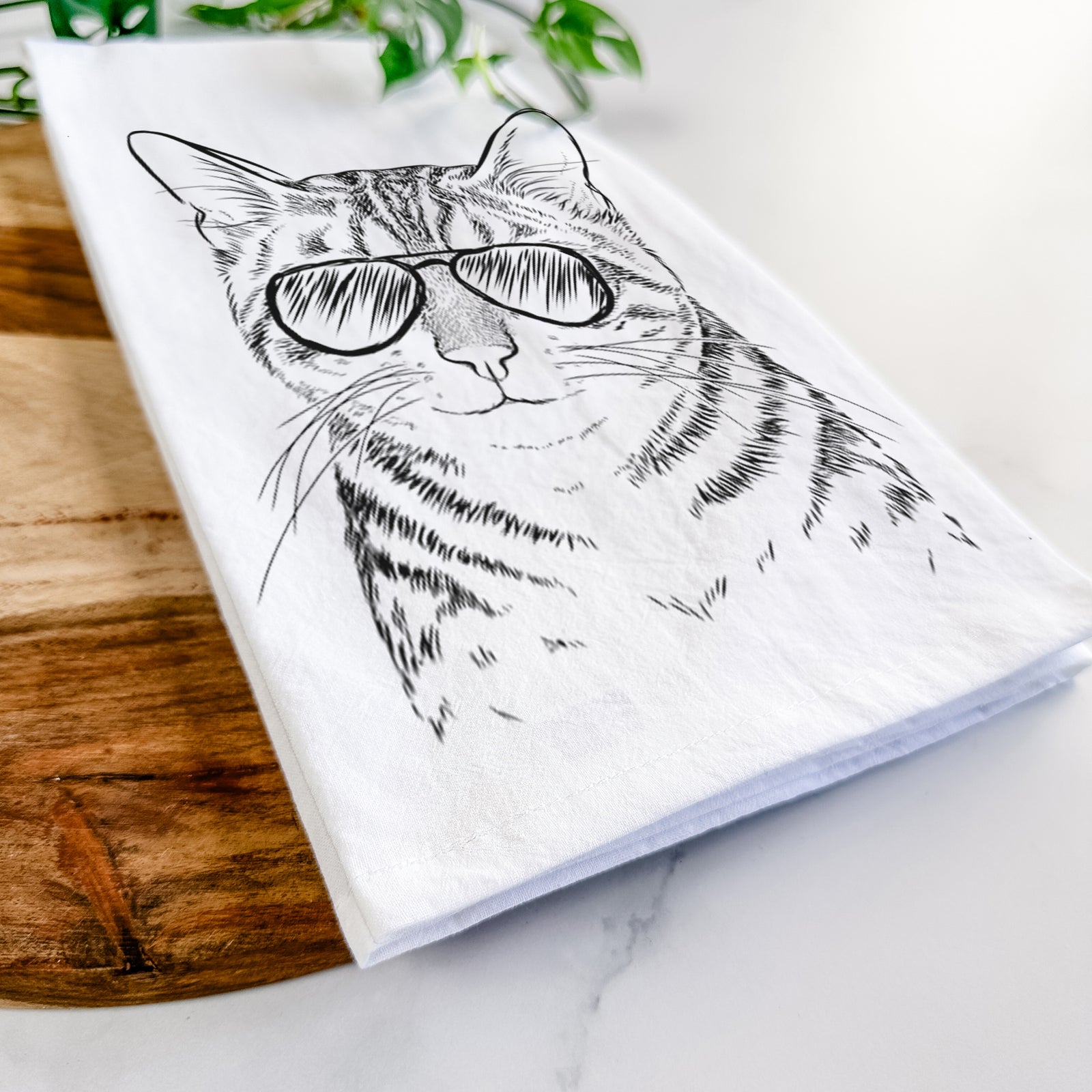 Hand-drawn sketch of Nell the Tabby Cat wearing aviator sunglasses on a tea towel
