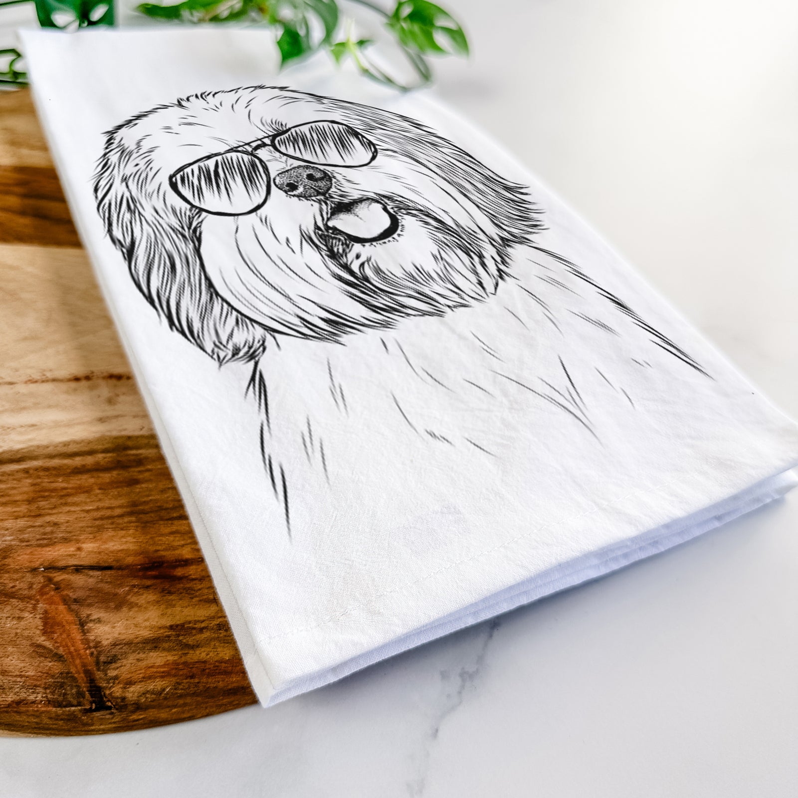 Hand-drawn sketch of Nikka the Lowchen wearing aviator sunglasses on a tea towel