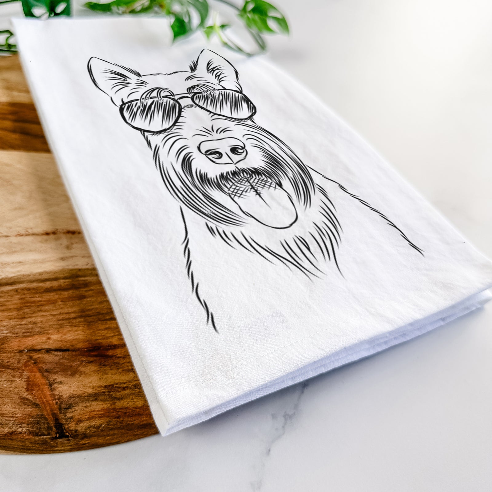 Hand-drawn sketch of Oswald the Scottish Terrier wearing aviator sunglasses on a tea towel