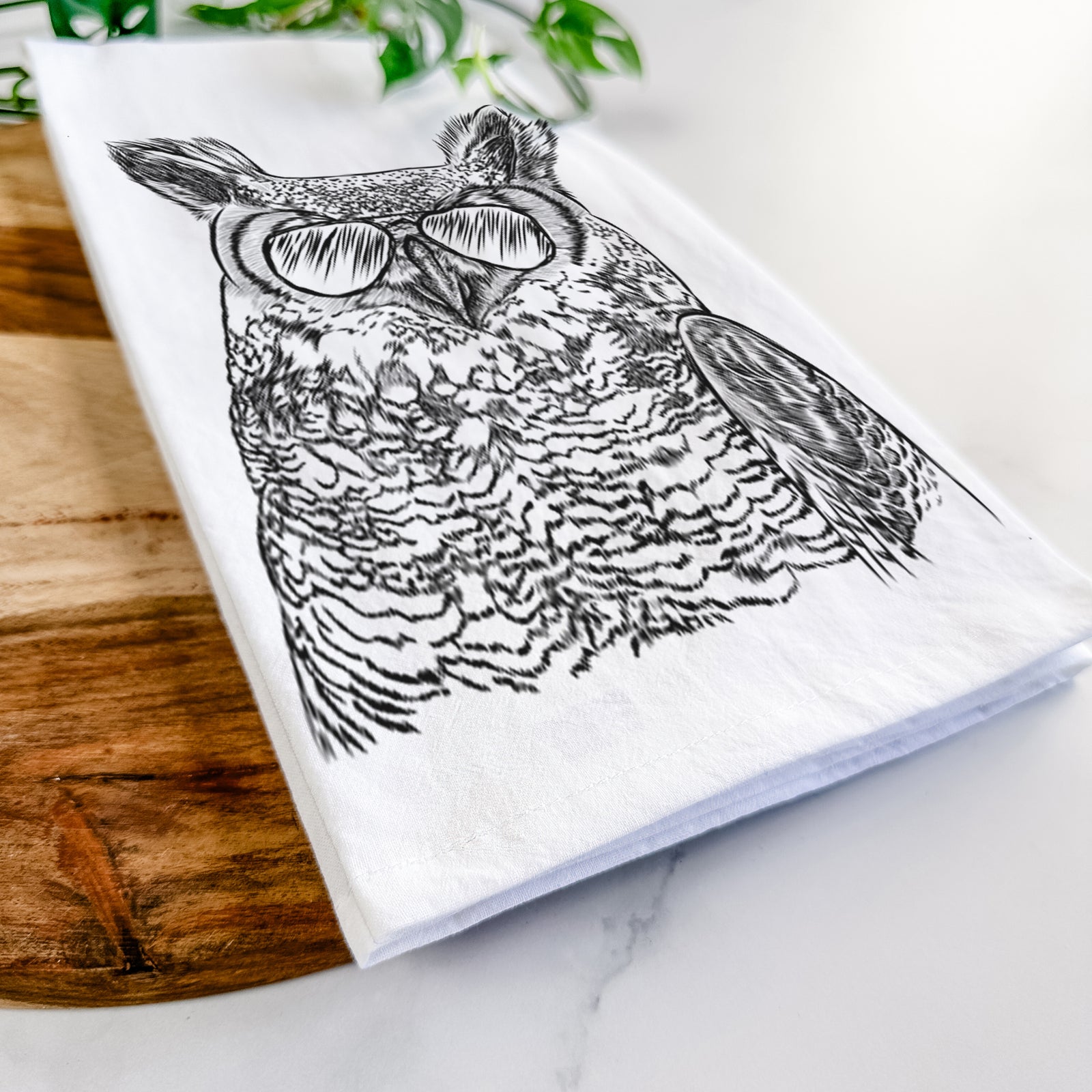 Hand-drawn sketch of Ozwald the Grey Horned Owl wearing aviator sunglasses on a tea towel