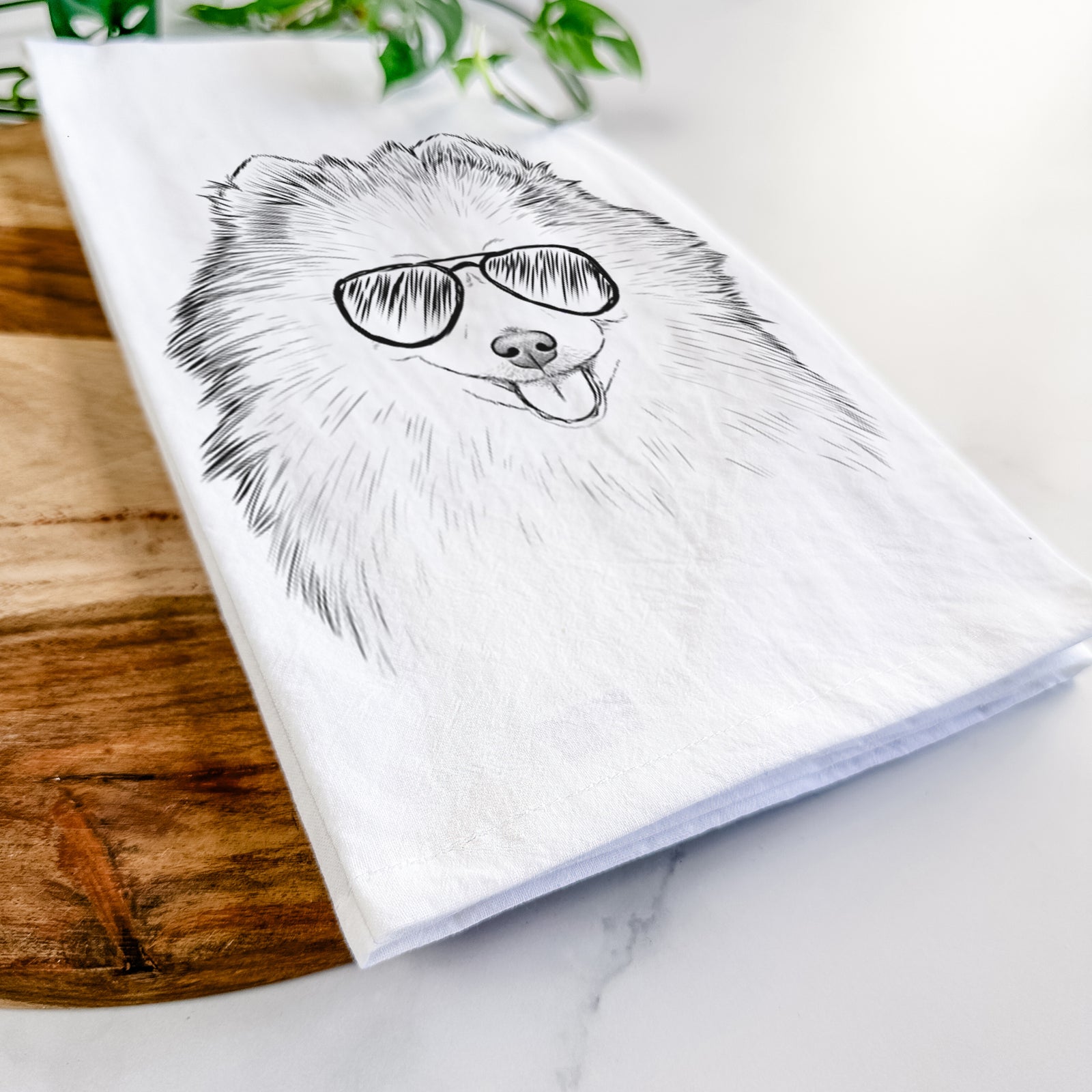 Hand-drawn sketch of Piper Jo the Pomeranian wearing aviator sunglasses on a tea towel