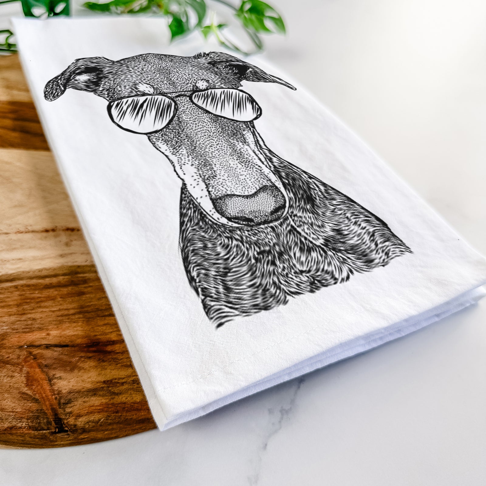 Hand-drawn sketch of Princess Fiona the Doberman Pinscher wearing aviator sunglasses on a tea towel