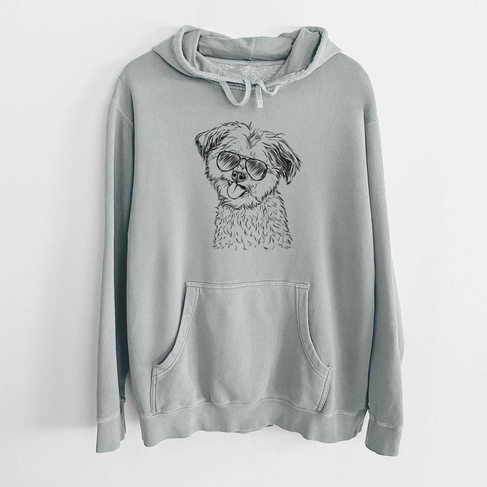 Hand-drawn sketch of Puff the Malshi wearing aviator sunglasses on a Sage Unisex pigment dyed hoodie