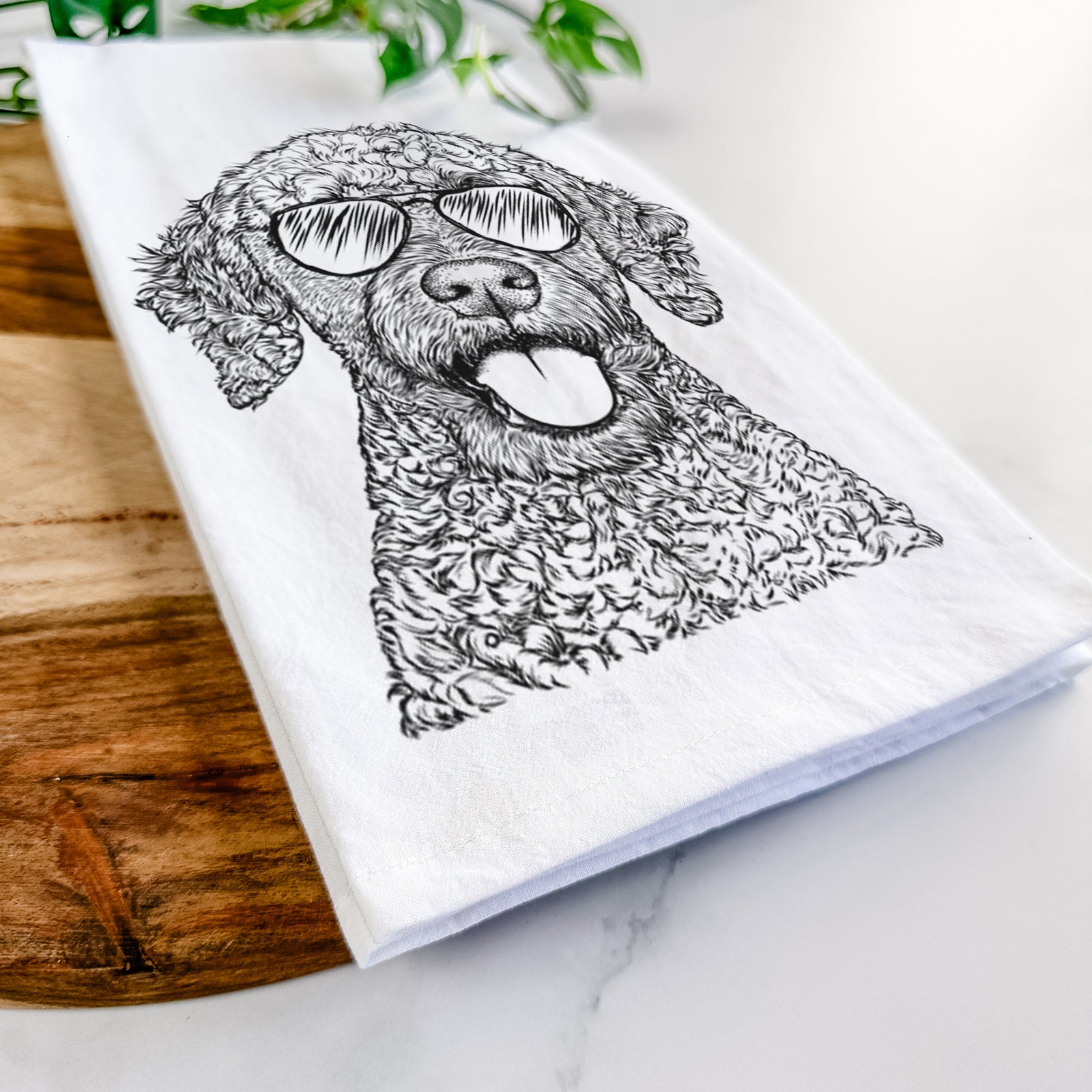 Hand-drawn sketch of Reina the Spanish Water Dog wearing aviator sunglasses on a tea towel