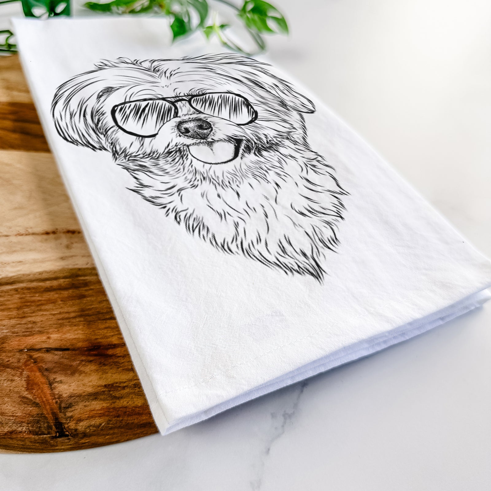 Hand-drawn sketch of Rosie the Maltipoo wearing aviator sunglasses on a tea towel