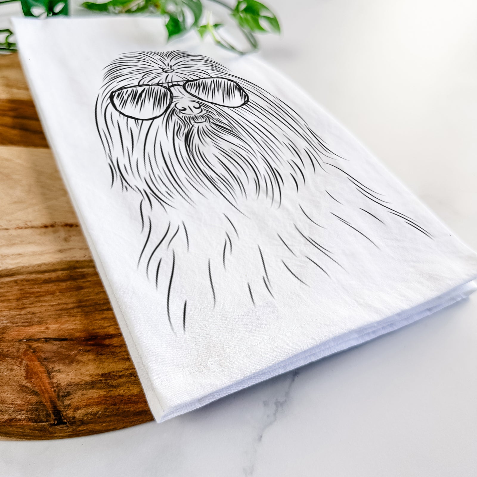 Hand-drawn sketch of Sabine the Shih Tzu wearing aviator sunglasses on a tea towel