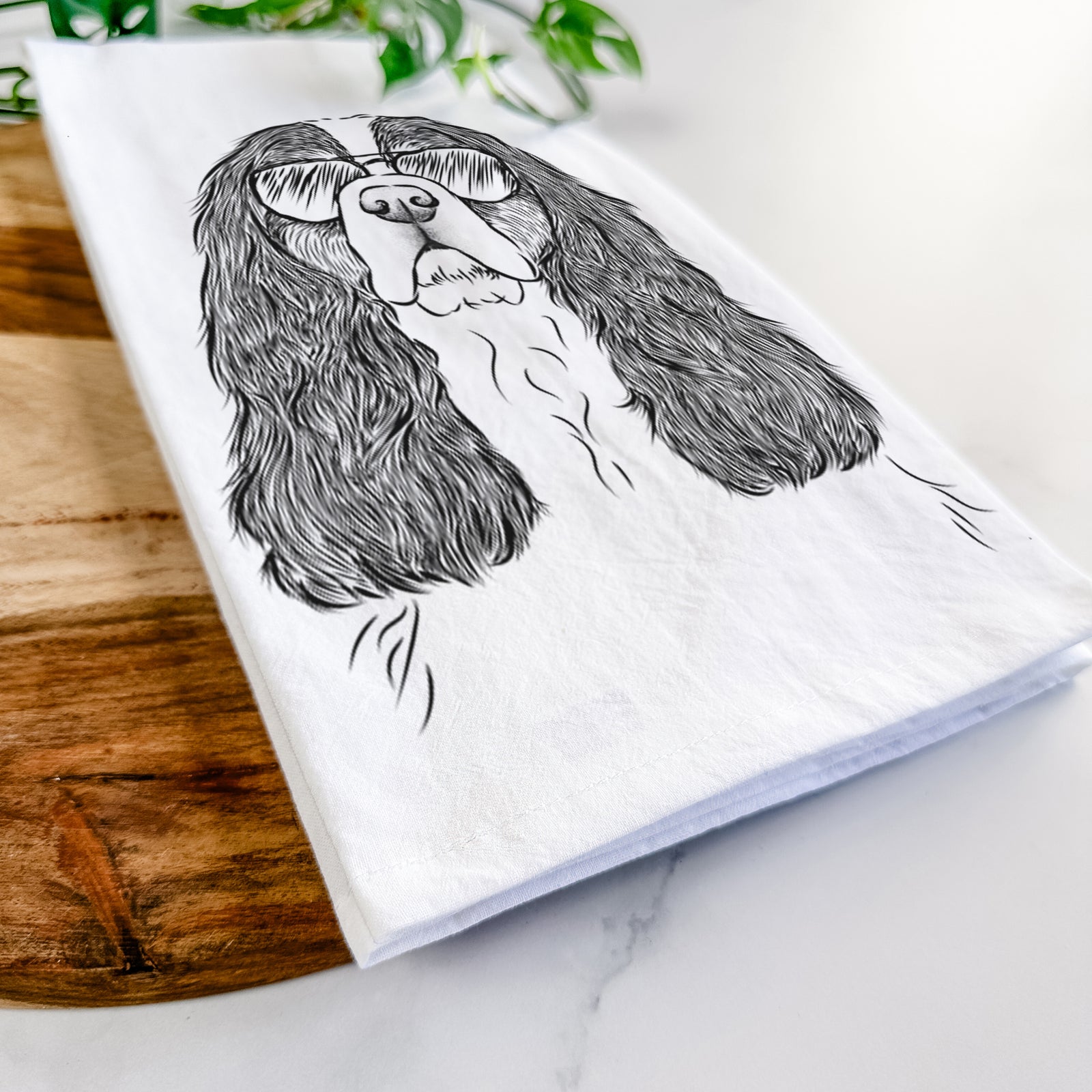 Hand-drawn sketch of Sebastian the Cavalier King Charles Spaniel wearing aviator sunglasses on a tea towel