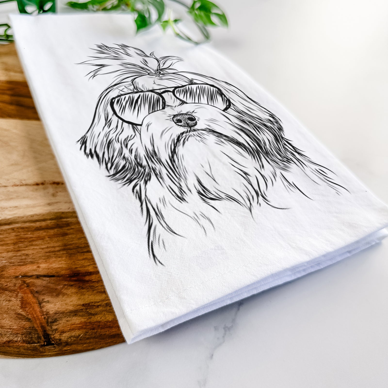 Hand-drawn sketch of Tootsie the Lowchen wearing aviator sunglasses on a tea towel