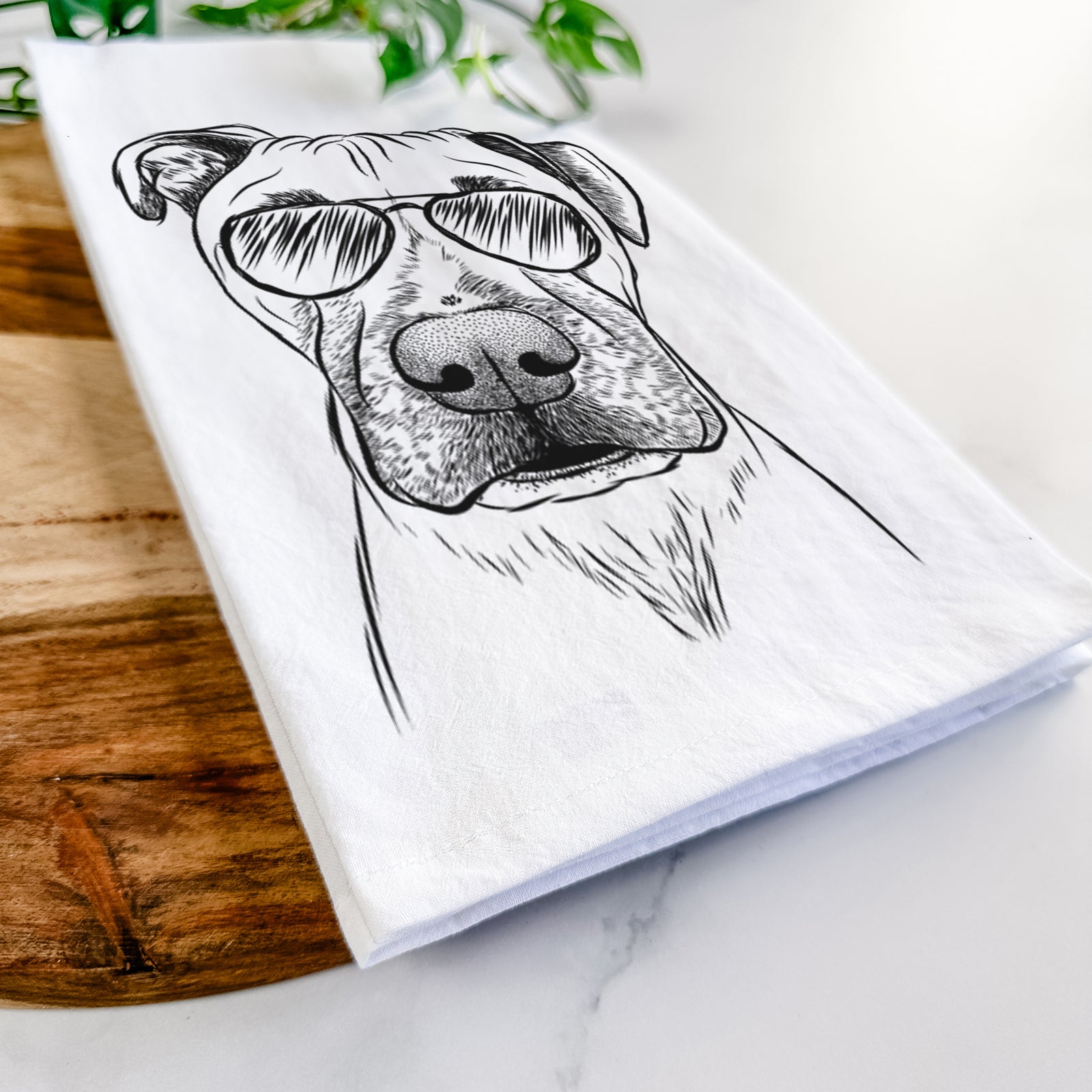Hand-drawn sketch of Waylon the Boxane wearing aviator sunglasses on a tea towel