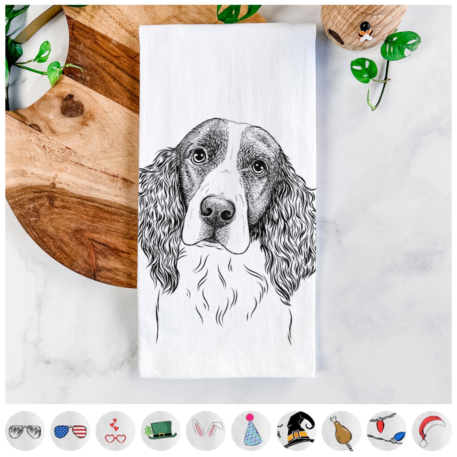 Hand-drawn sketch of Annie the English Springer Spaniel on a tea towel, shown with icons of the other available costume styles