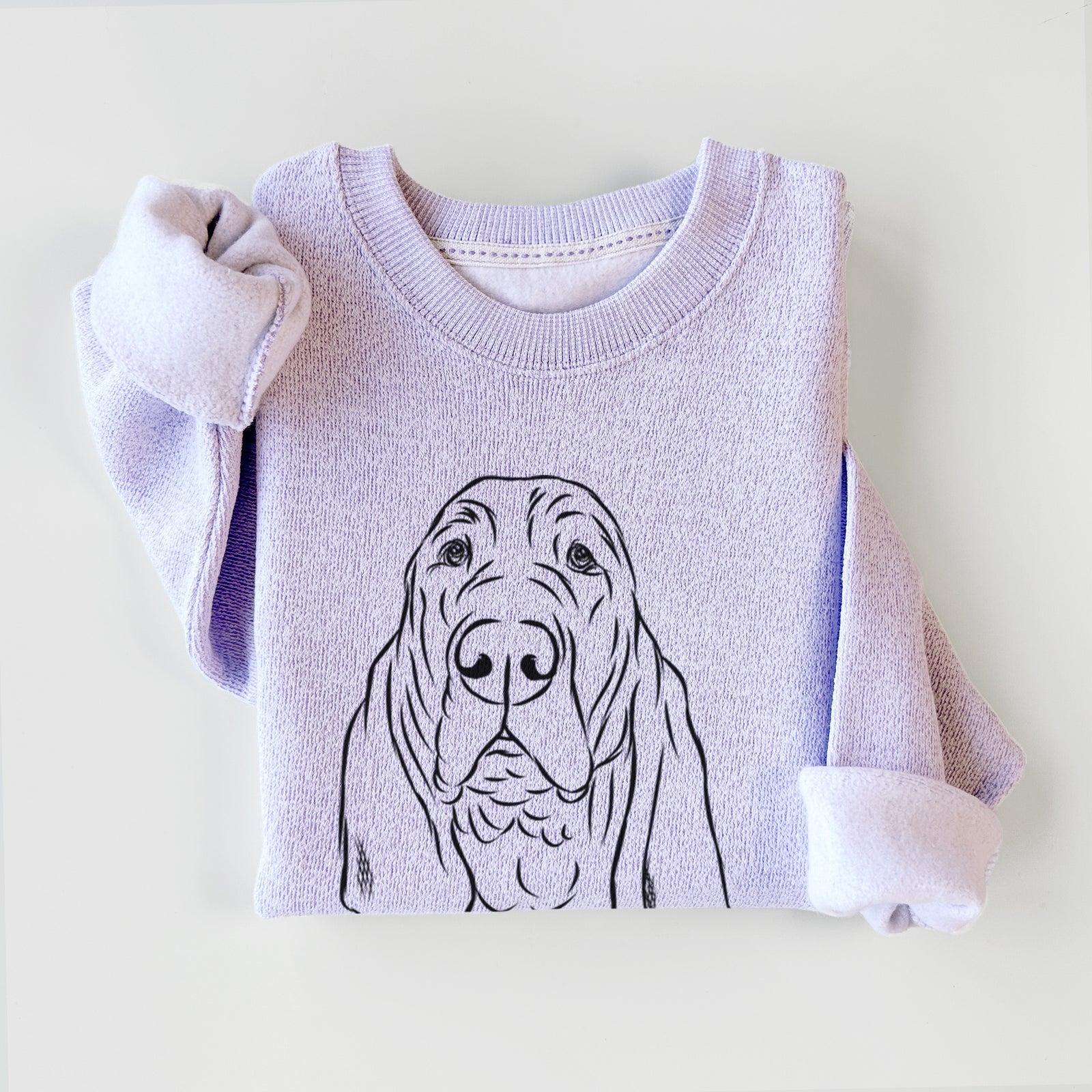 Hand-drawn sketch of Baron the Bloodhound on an Ice Purple knit sweatshirt