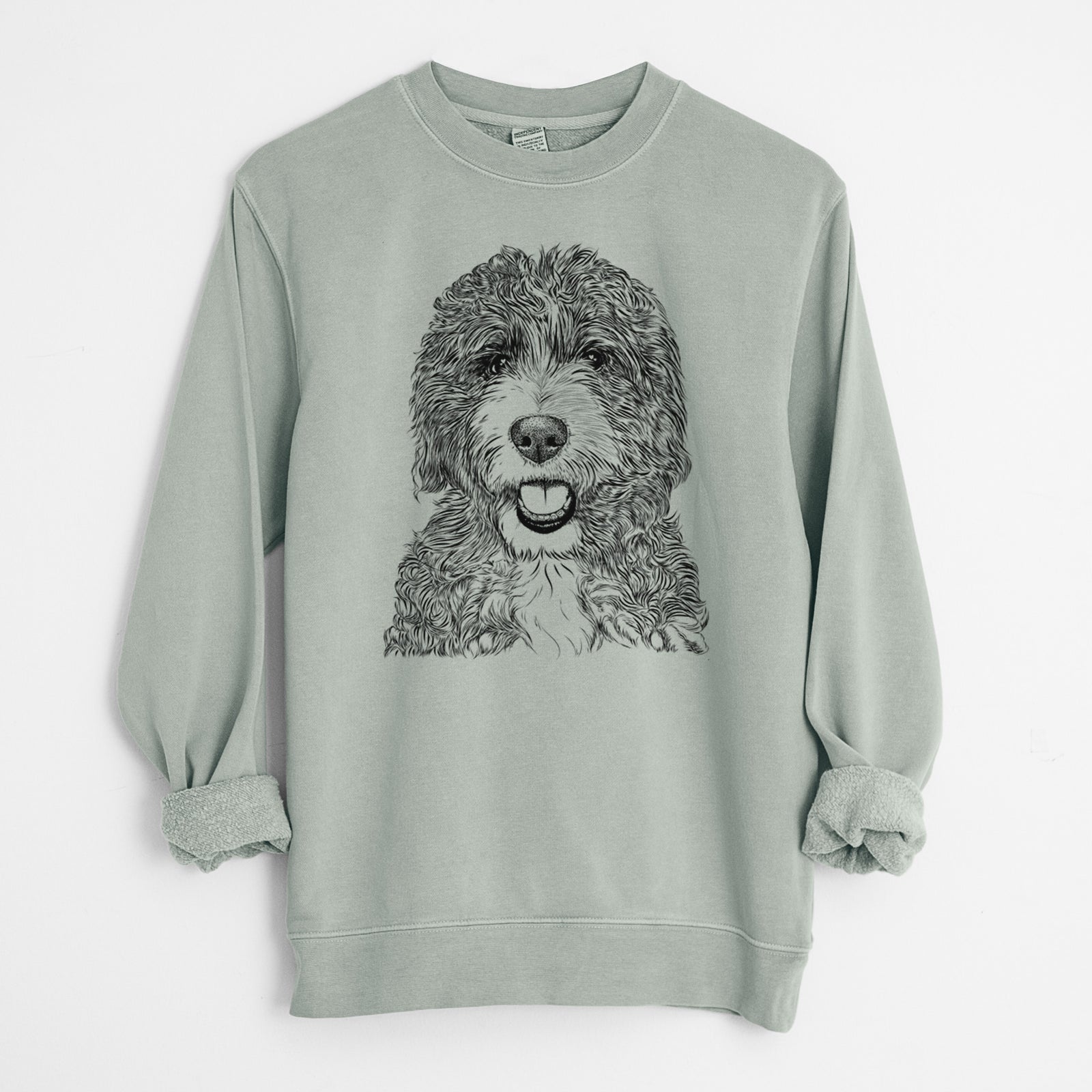 Hand-drawn sketch of Bash the Bernedoodle on a Sage Unisex pigment dyed crew sweatshirt
