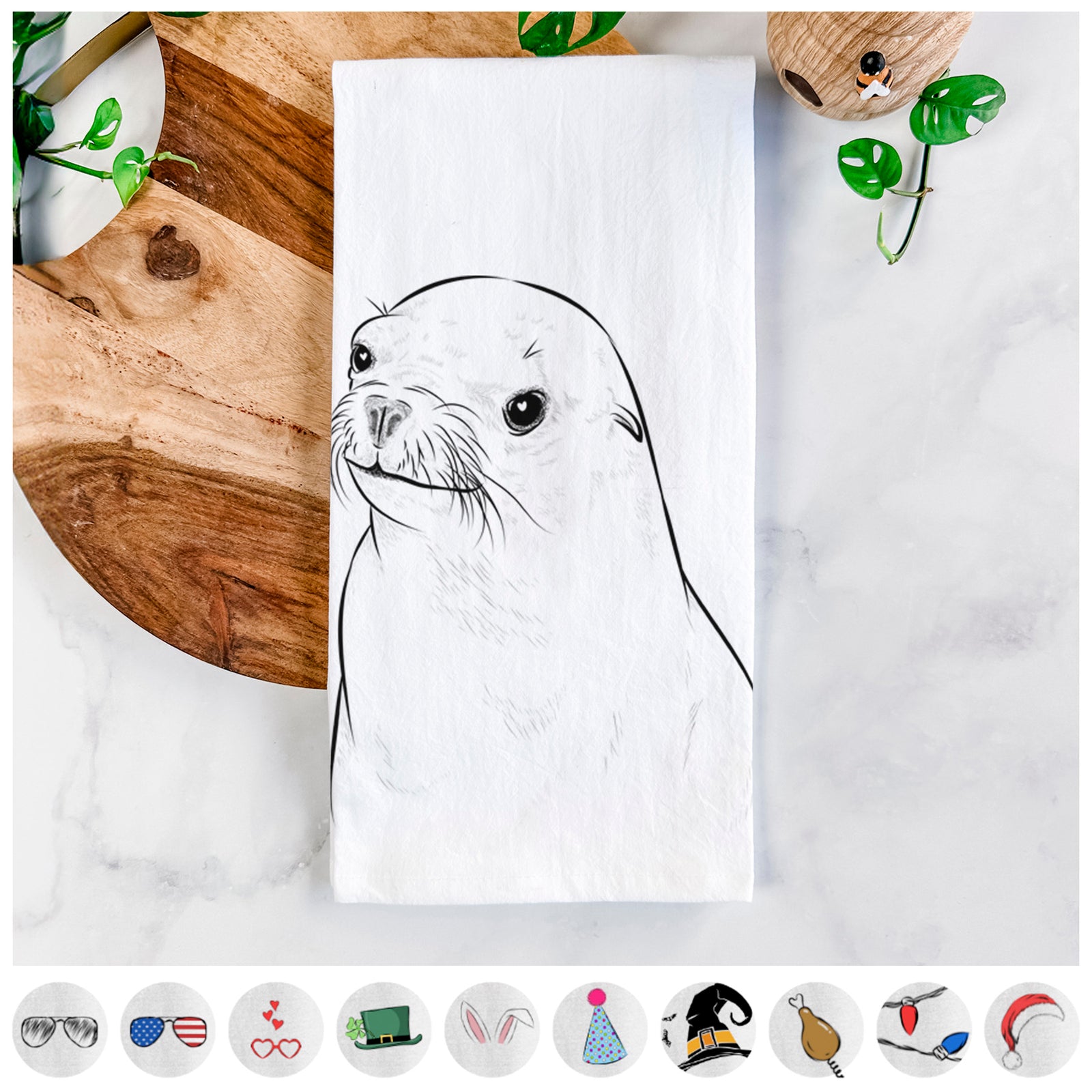 Hand-drawn sketch of Chip the California Sea Lion on a tea towel, shown with icons of the other available costume styles