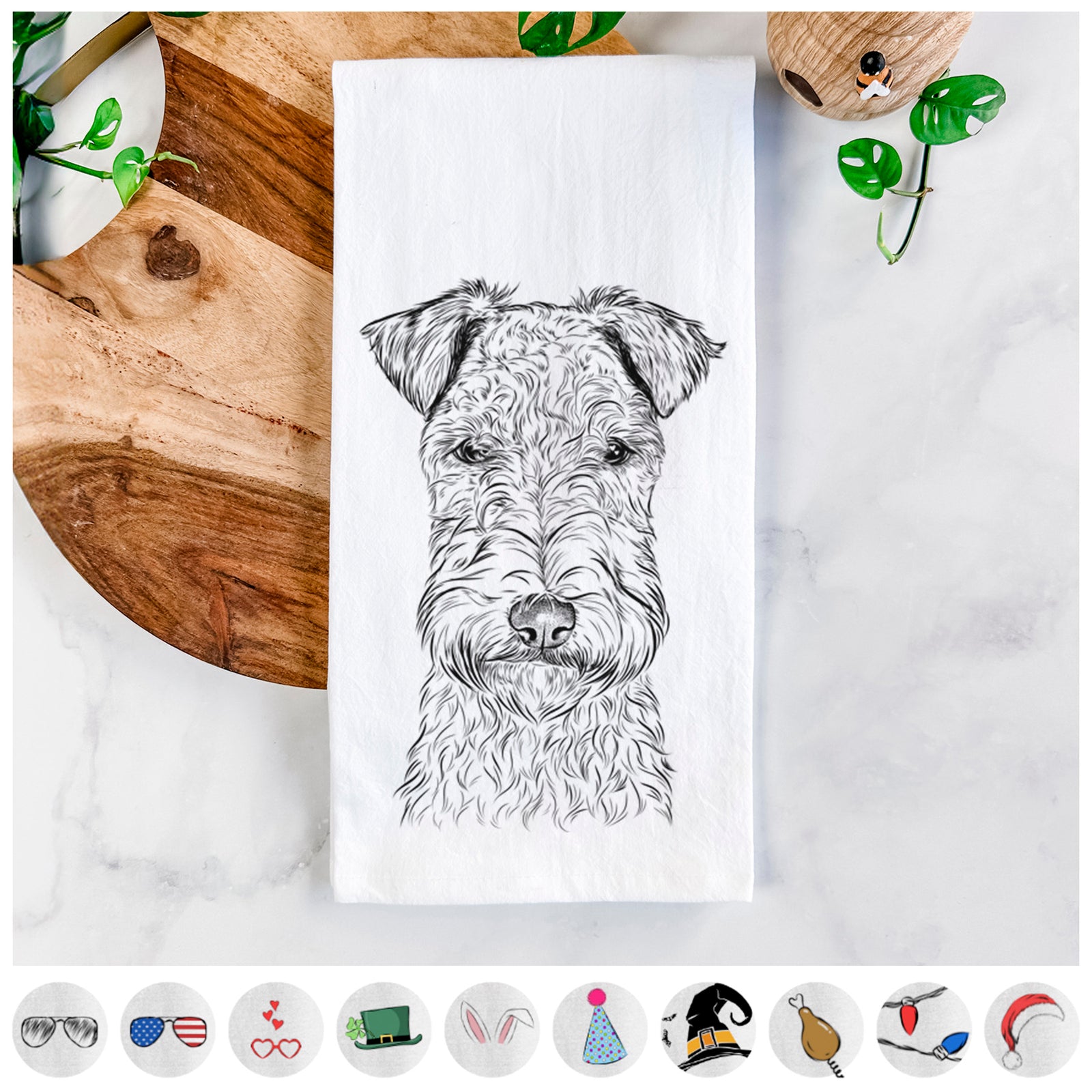 Hand-drawn sketch of Frida the Lakeland Terrier on a tea towel, shown with icons of the other available costume styles