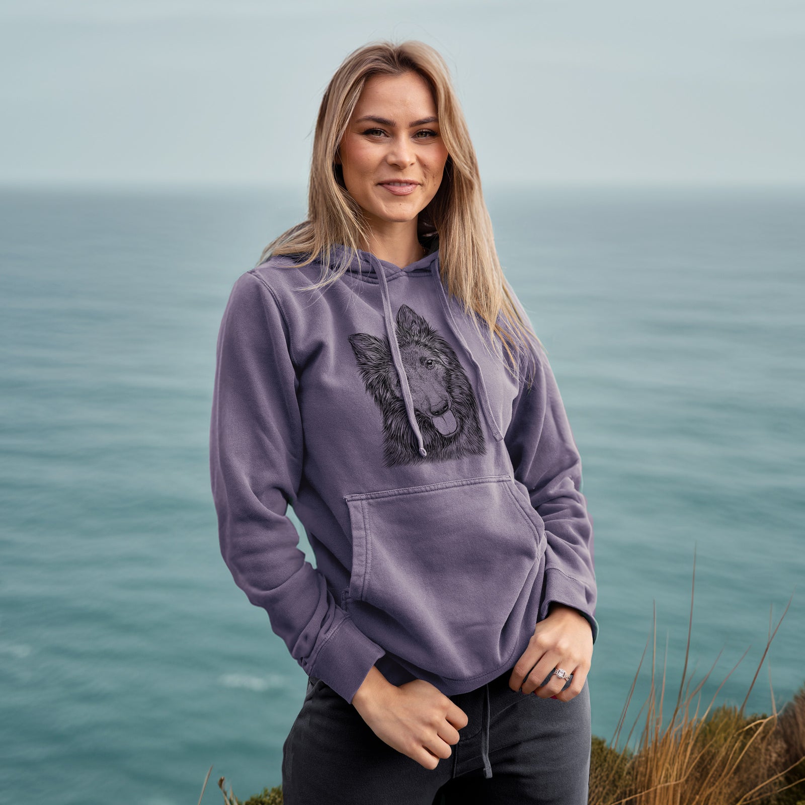 Hand-drawn sketch of Jaxx the Belgian Tervuren on a Plum Unisex pigment dyed hoodie, worn by a woman