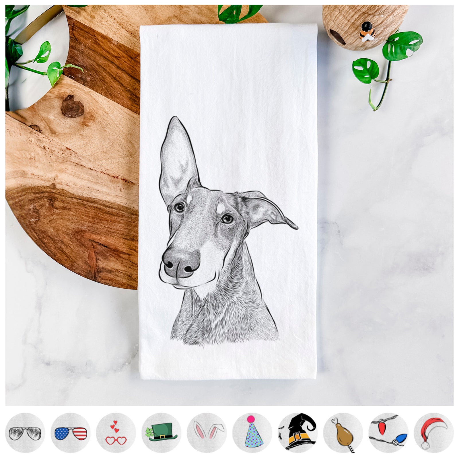 Hand-drawn sketch of Kain the Doberman Pinscher on a tea towel, shown with icons of the other available costume styles
