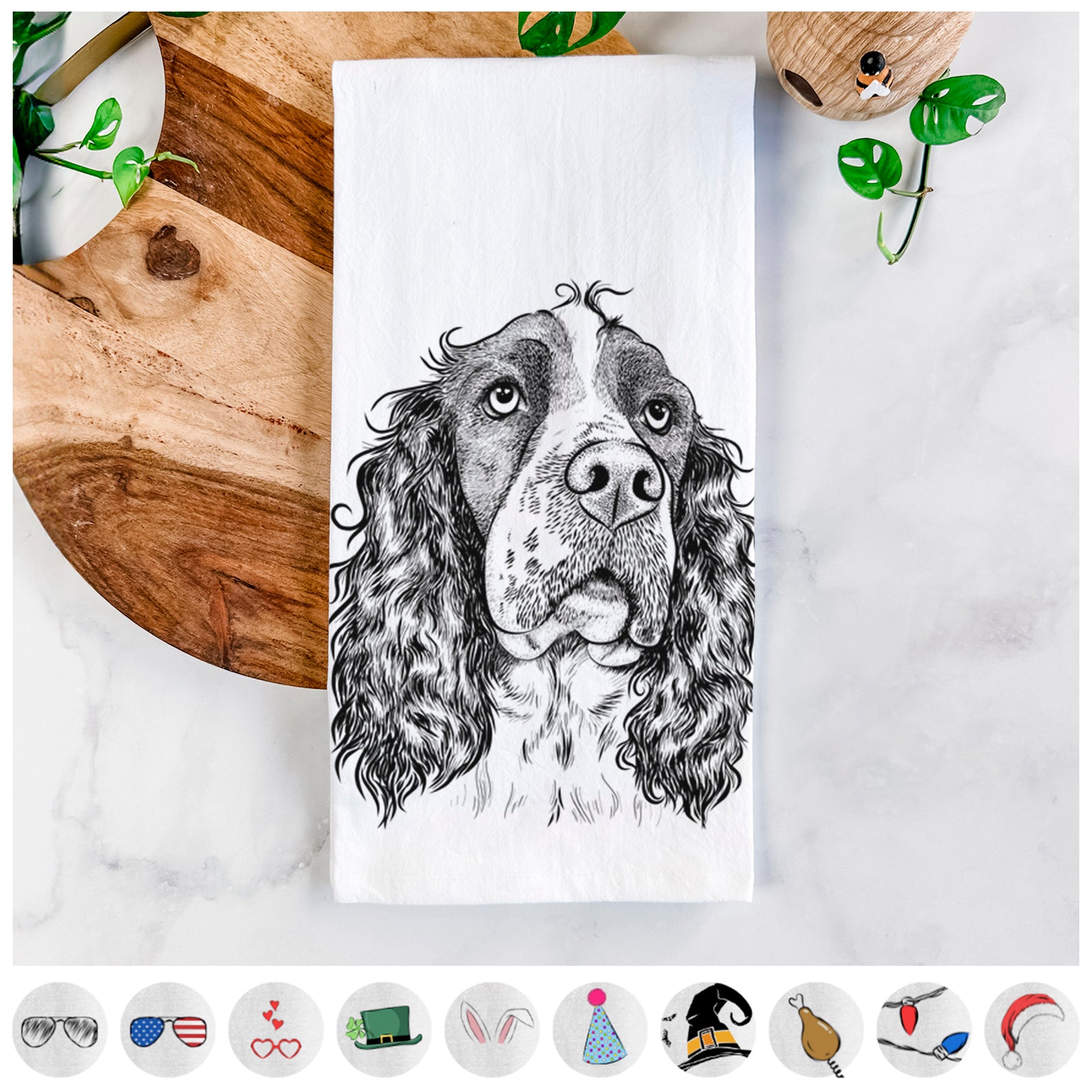 Hand-drawn sketch of Millie Mae the English Springer Spaniel on a tea towel, shown with icons of the other available costume styles