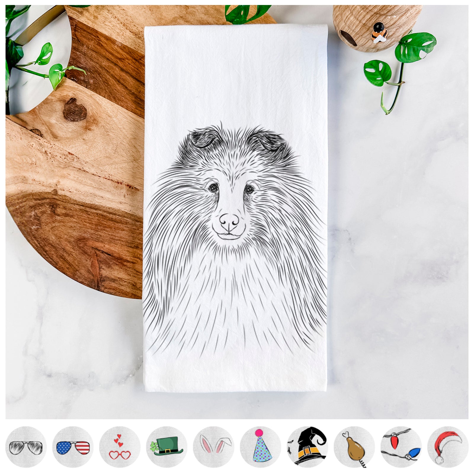Hand-drawn sketch of Moxie the Shetland Sheepdog on a tea towel, shown with icons of the other available costume styles