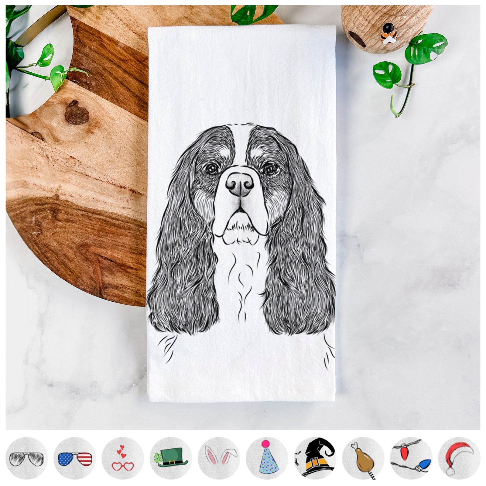 Hand-drawn sketch of Sebastian the Cavalier King Charles Spaniel on a tea towel, shown with icons of the other available costume styles