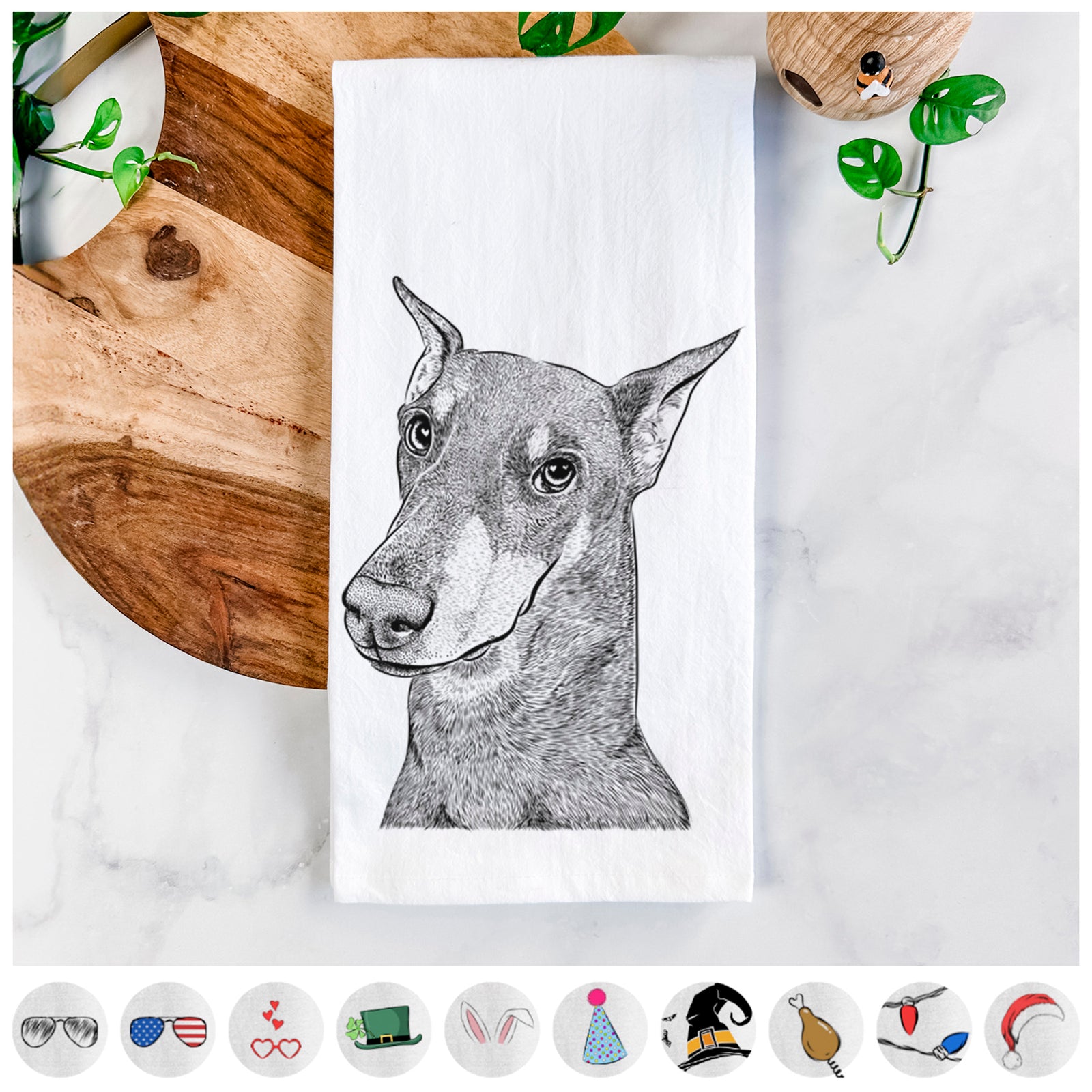 Hand-drawn sketch of Shelby the Doberman Pinscher on a tea towel, shown with icons of the other available costume styles