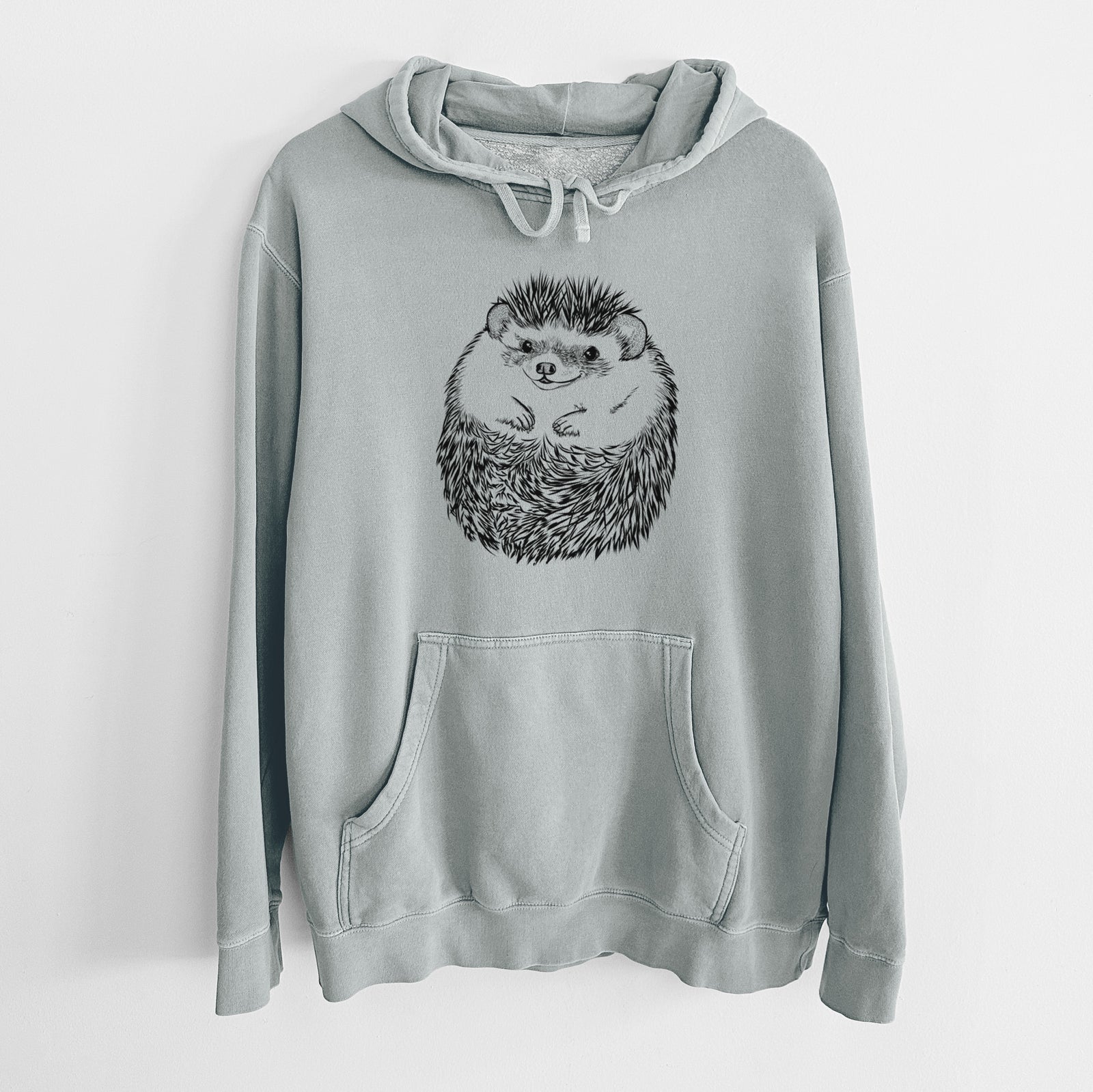 Hand-drawn sketch of Sid the Hedgehog on a Sage Unisex pigment dyed hoodie
