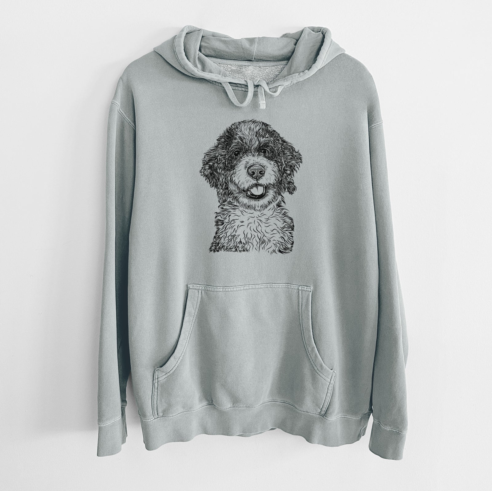 Hand-drawn sketch of Smoky the Bernedoodle Puppy on a Sage Unisex pigment dyed hoodie