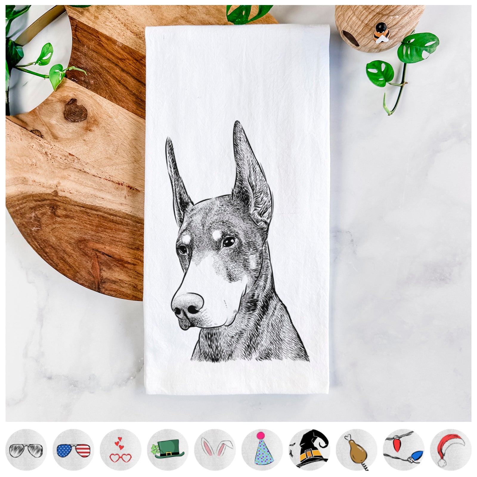 Hand-drawn sketch of Sunny the Doberman Pinscher on a tea towel, shown with icons of the other available costume styles